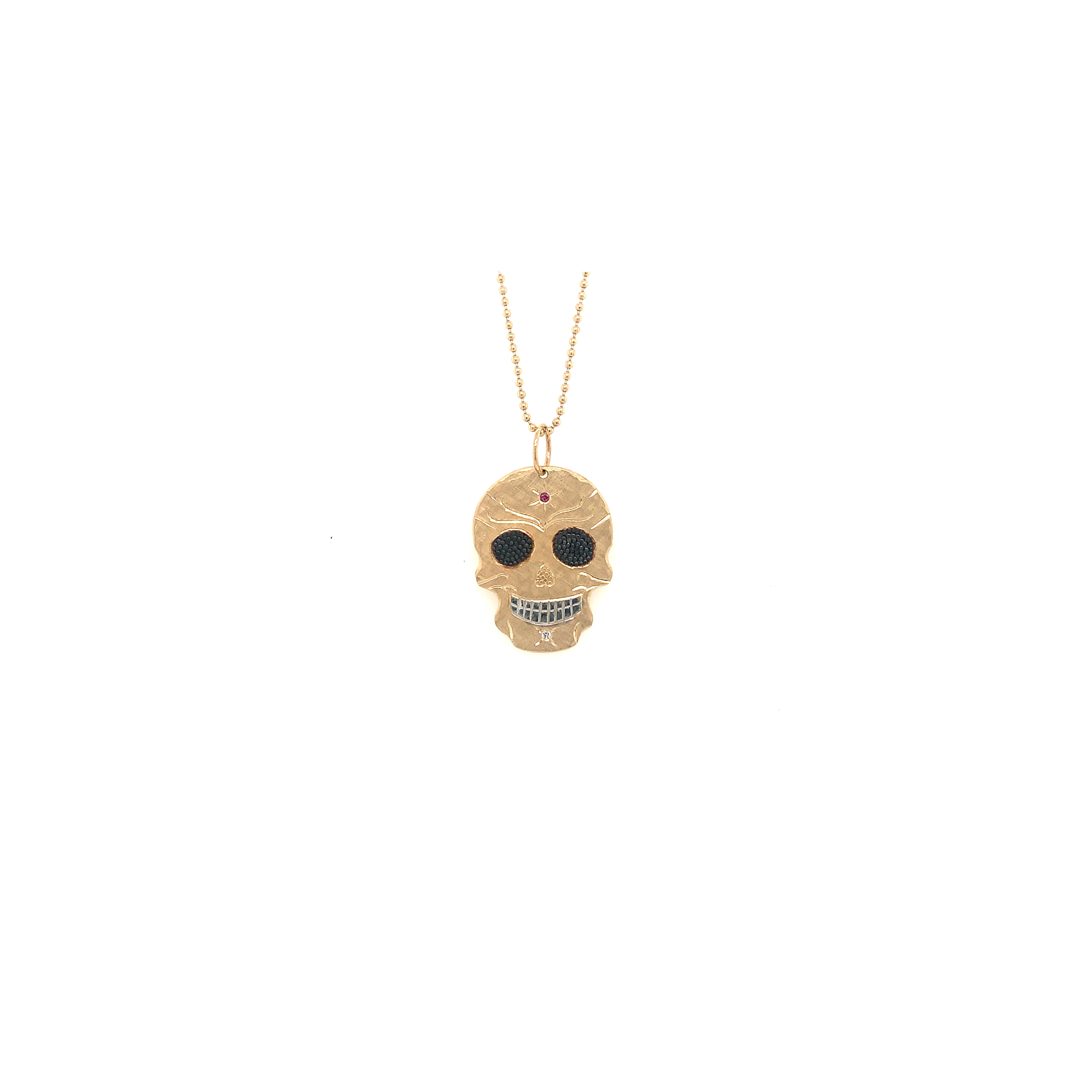 14k Gold Medium Size Candy Skull Pendant with blackened eyes and colored sapphire stone on a chain on a white background by Julez Bryant