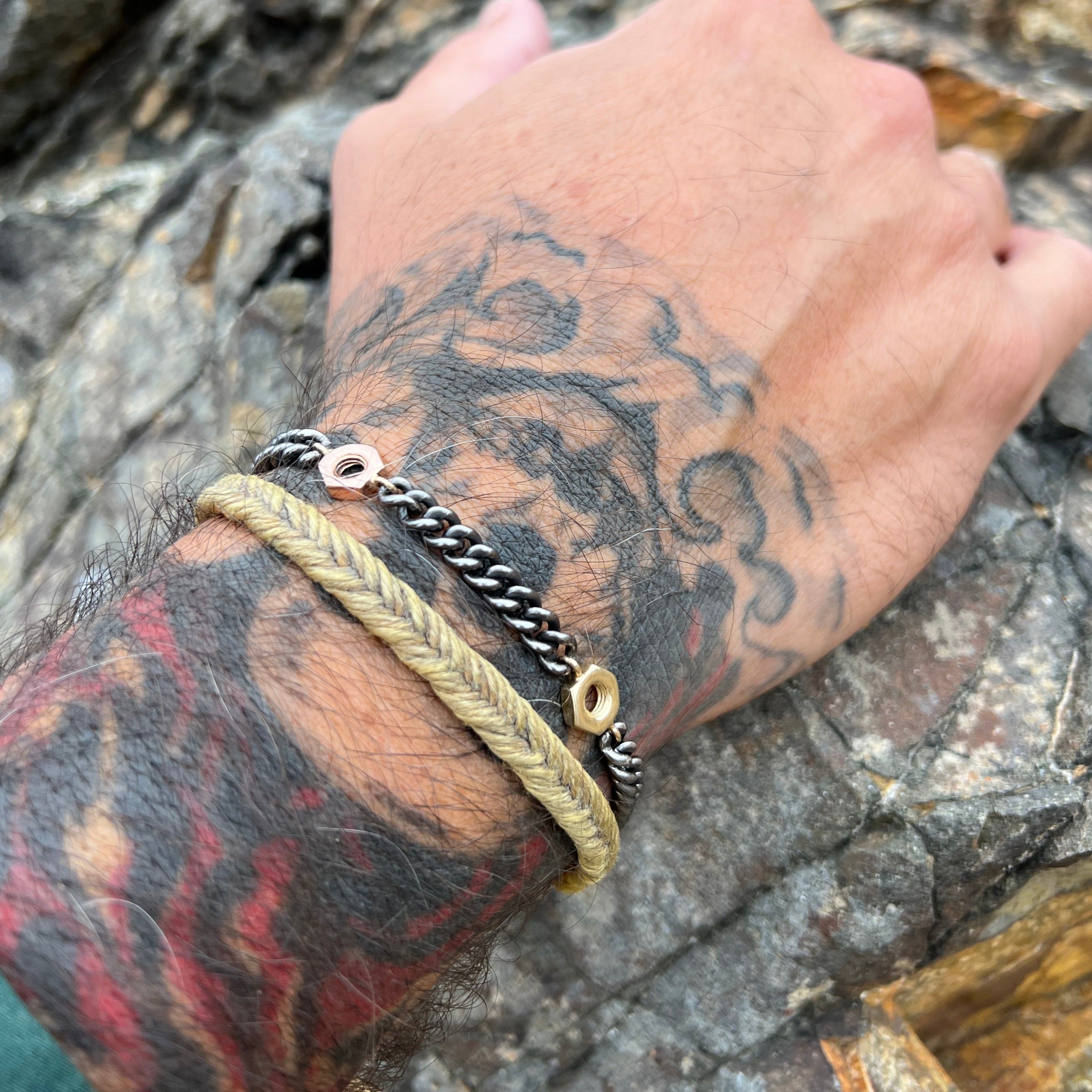 blackened sterling silver curb link chain bracelet with alternating 14k yellow and rose gold nut accents on model in lifestyle shot