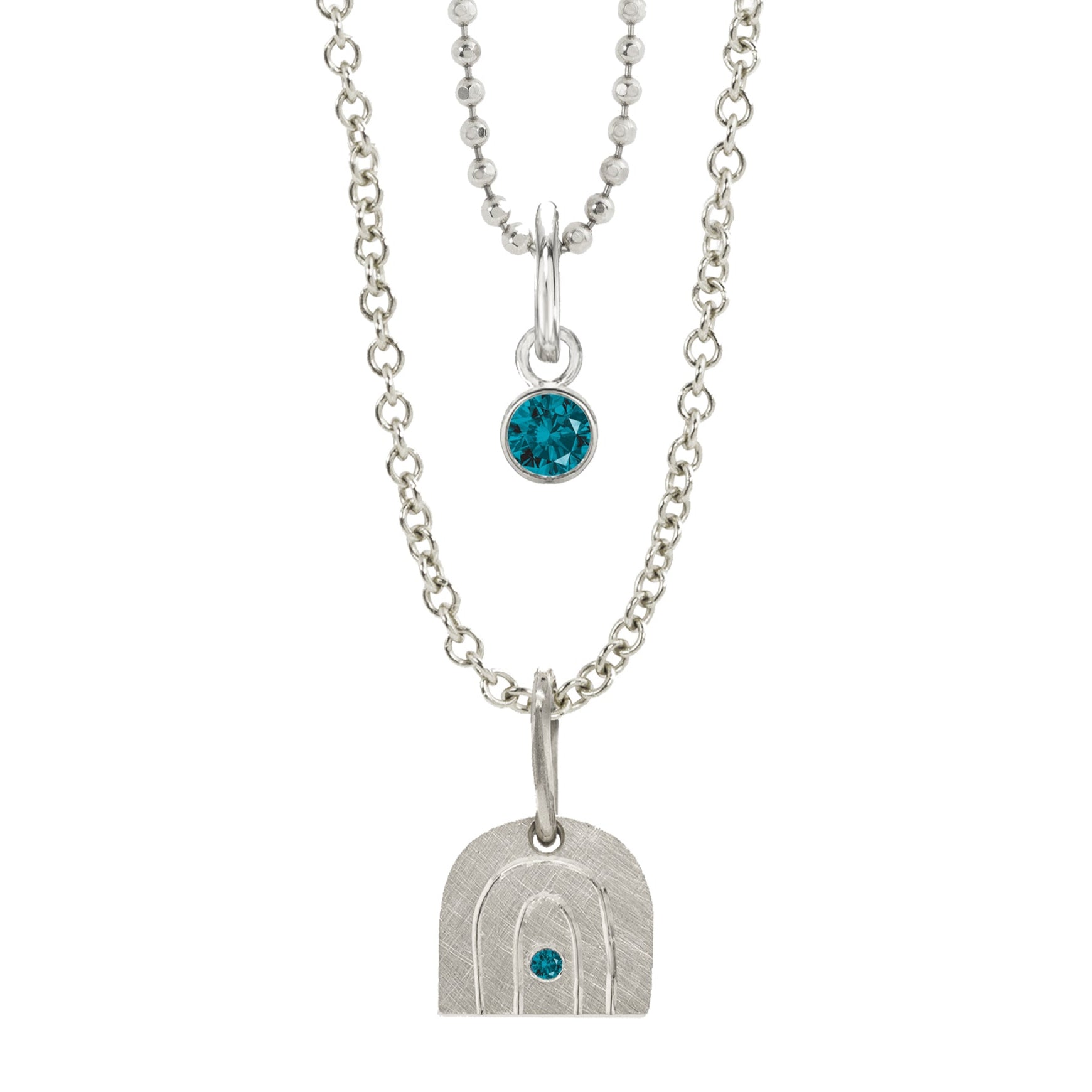 14k white gold bezel set teal diamond charm on diamond cut ball chain paired with white gold teeny tiny joy charm on white gold rolo chain on white background