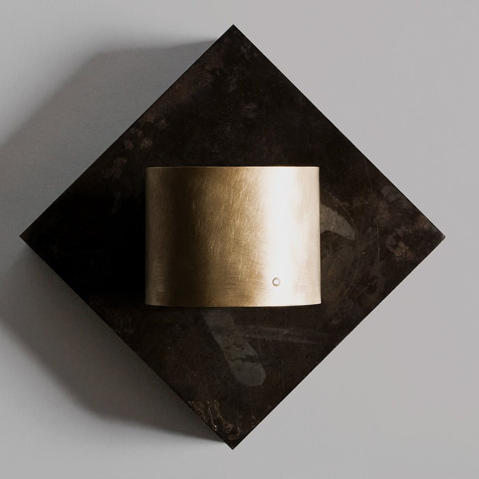 14k yellow gold wide statement cuff with satin finish and single white diamond accent on natural dark stone background