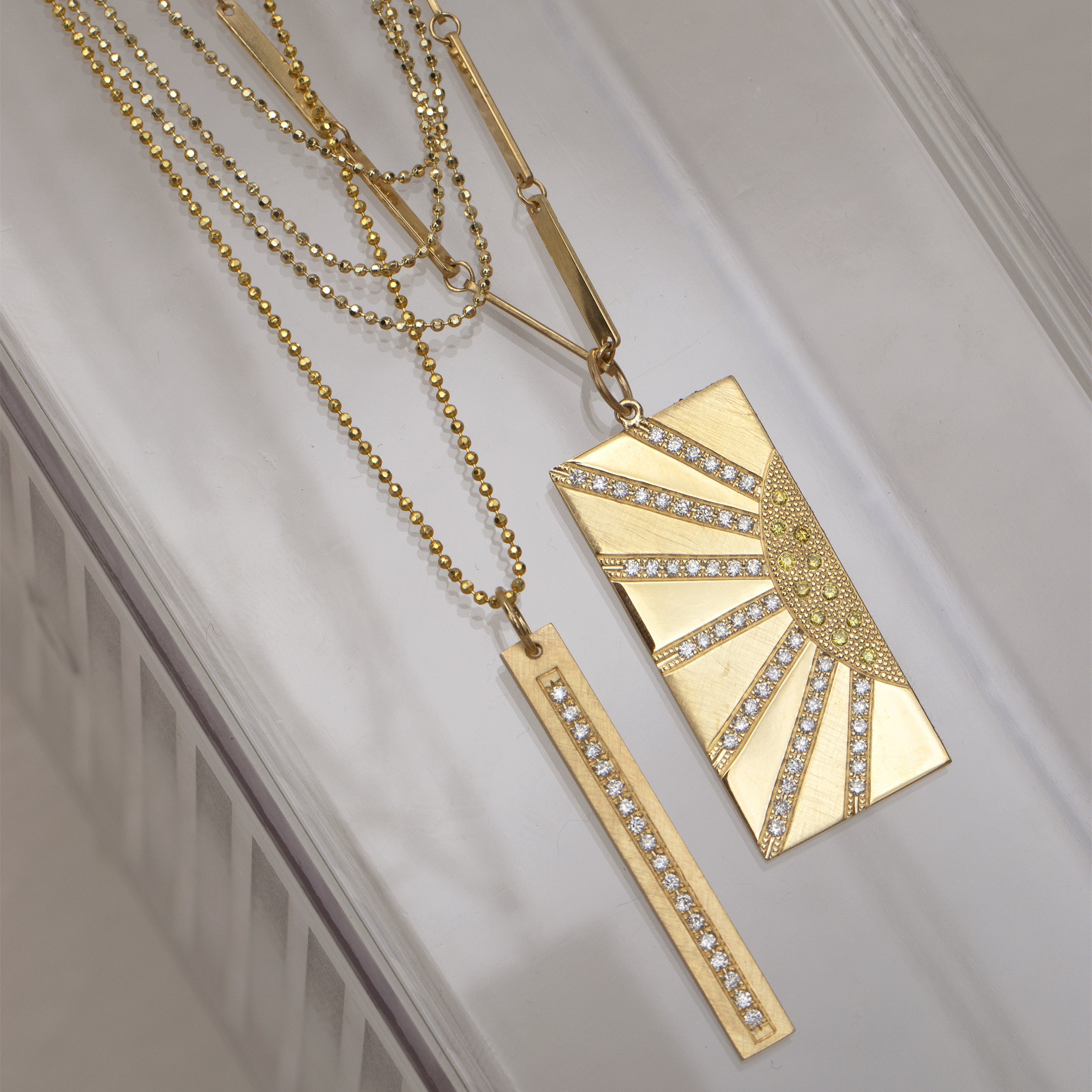 14k yellow gold vertical bar pendant with paved set white diamonds on diamond cut ball chain paired with hott pendant and chai necklace stacked still shot