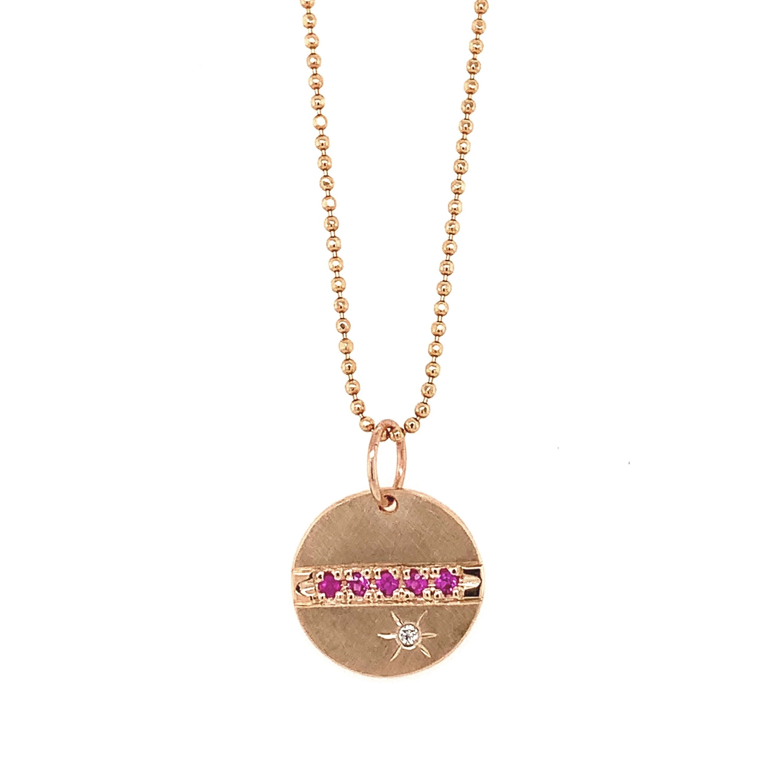 14k rose gold round pendant featuring pink sapphires and a white diamond sunburst on diamond cut ball chain on a white background