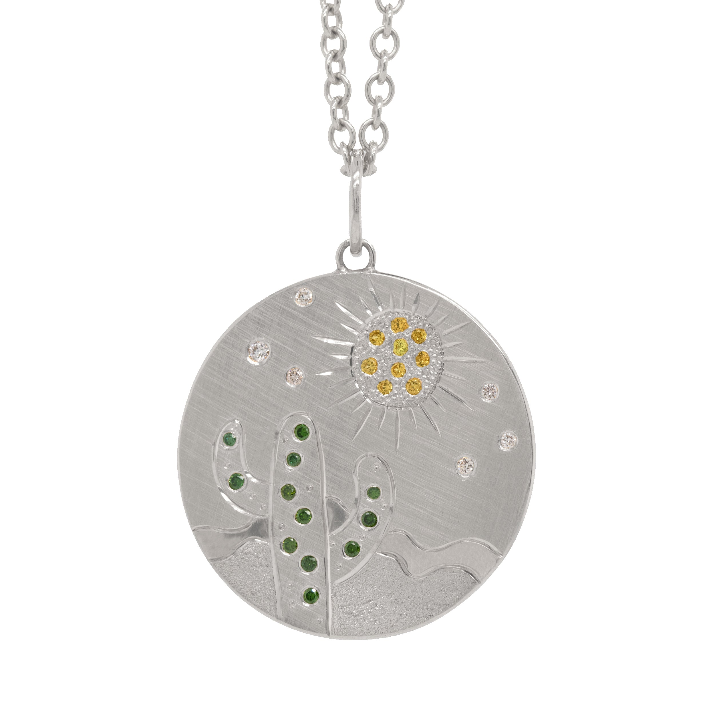 14k white gold round pendant featuring a hand etched cactus and sun design with colored sapphires and white diamonds on a rolo chain on a white background