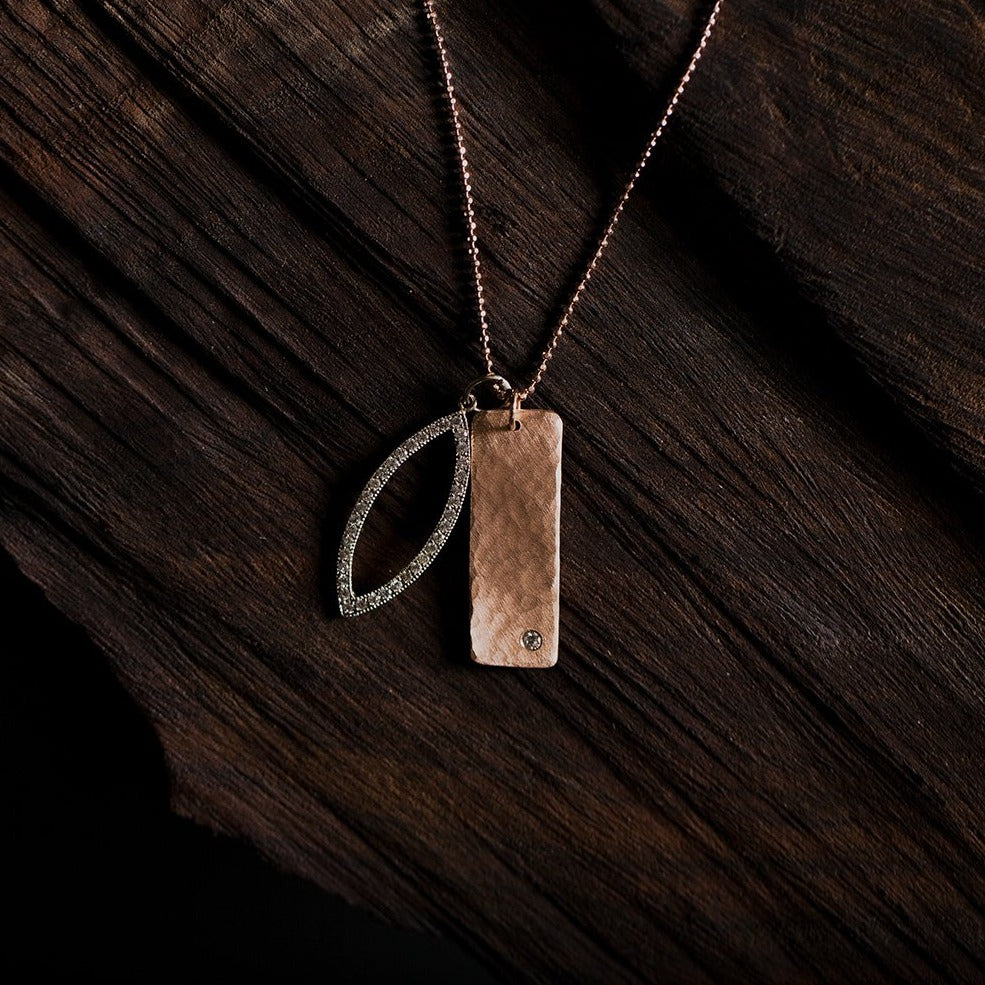 14k white gold marquis diamond charm stacked with rose gold rectangular niki bar featuring hammered finish and offset white diamond on diamond cut ball chain on natural wood background