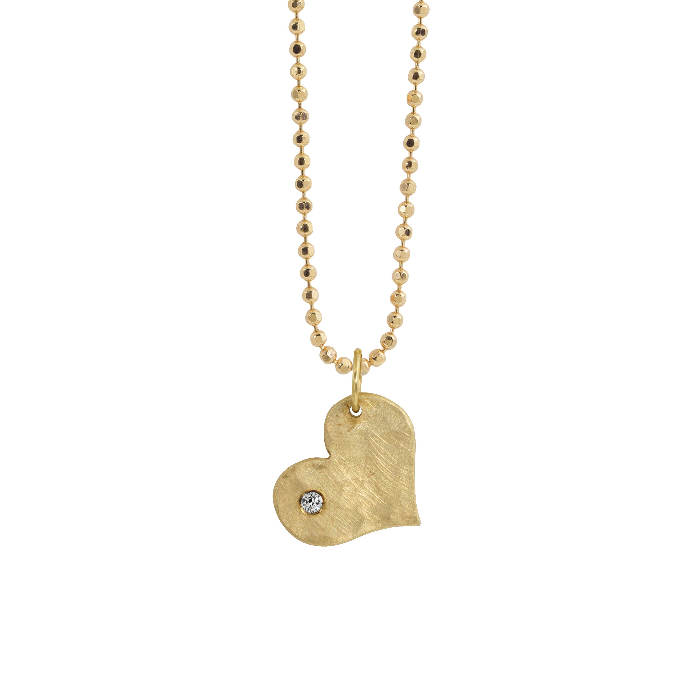 14k yellow gold heart-shaped pendant with an offset white diamond on diamond cut ball chain on a white background