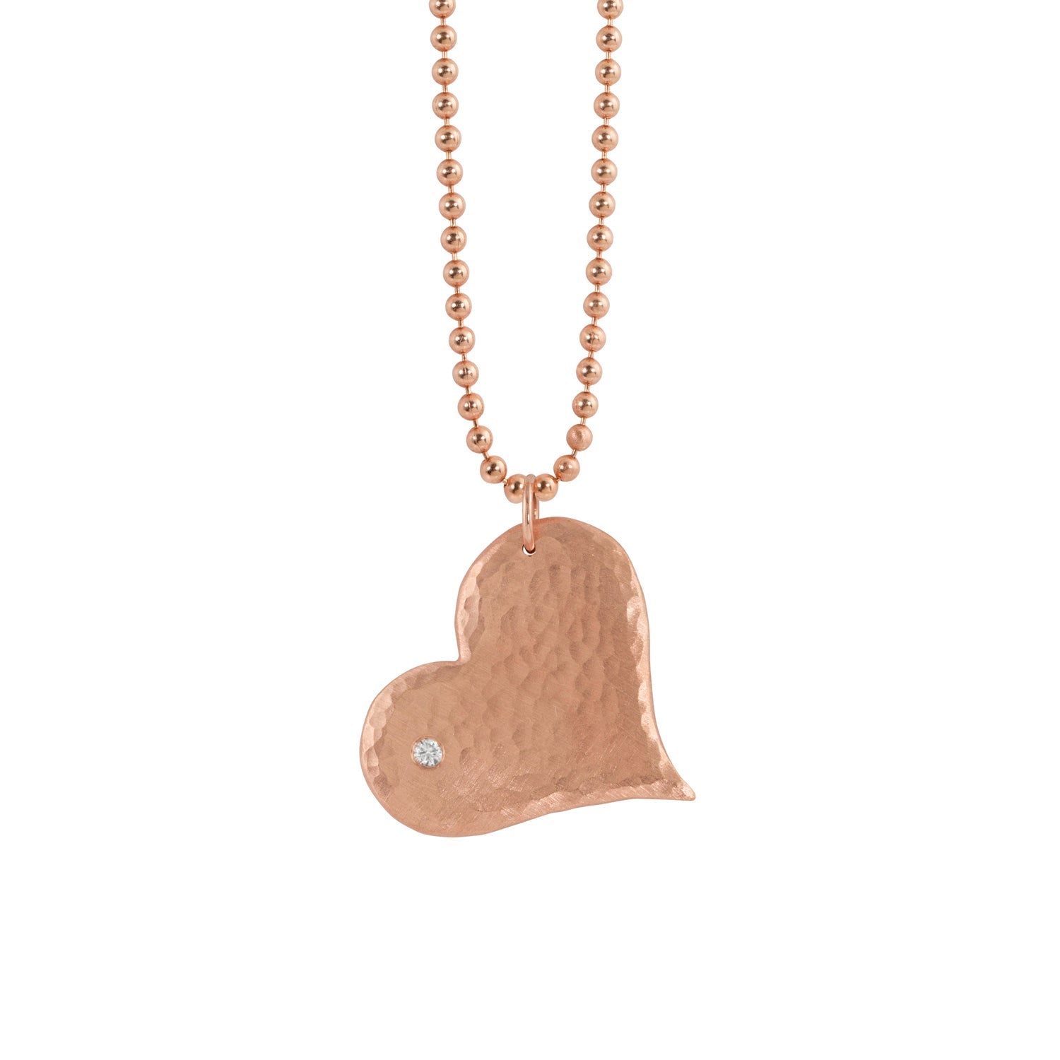 14k rose gold hammered heart-shaped pendant with a white diamond on a ball chain on a white background