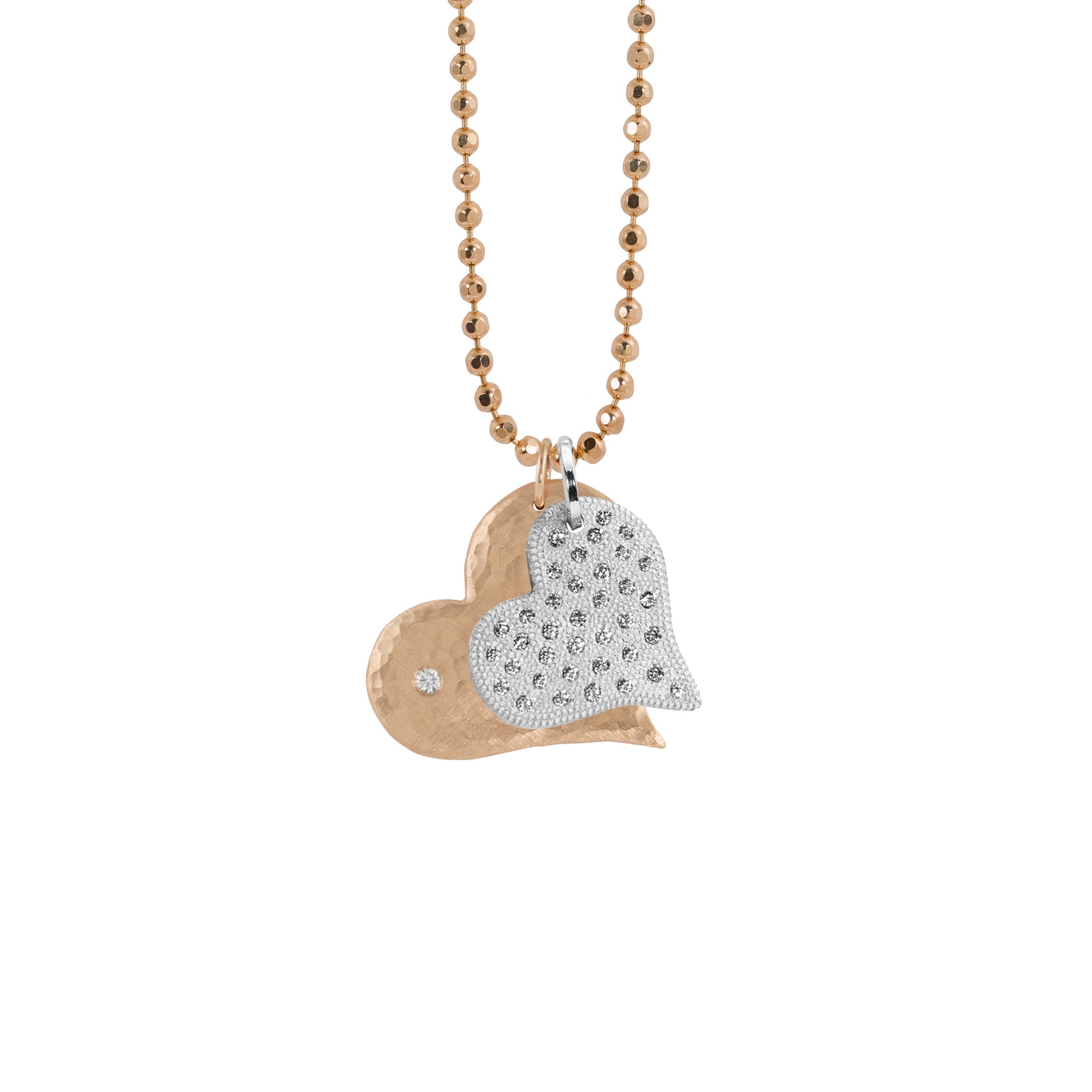 14k heart pendants featuring the lana in rose gold with a hammered finish and white diamond and the lava in white gold with beaded textures and scattered white diamonds on diamond cut ball chain on white background
