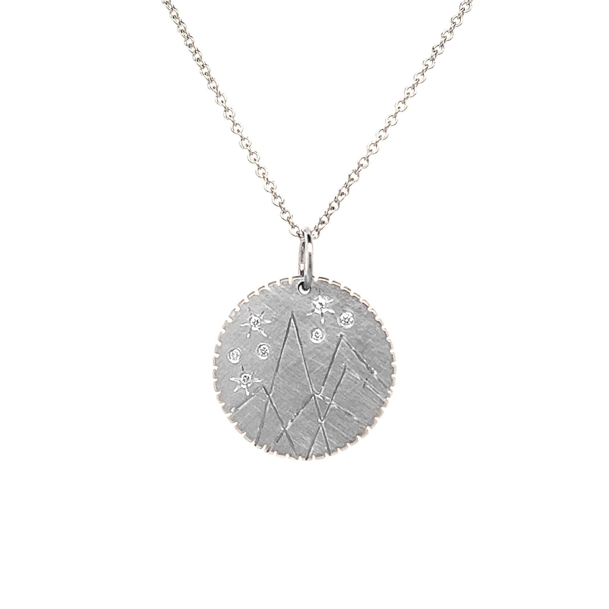 14k white gold round pendant with hand etched mountains and white diamond starbursts on rolo chain on a white background