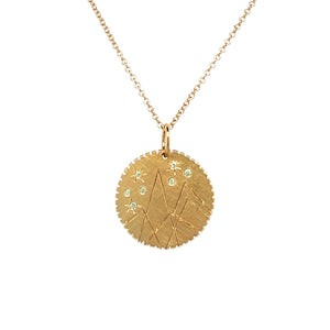 14k gold round pendant with mountains etching and white diamond details.