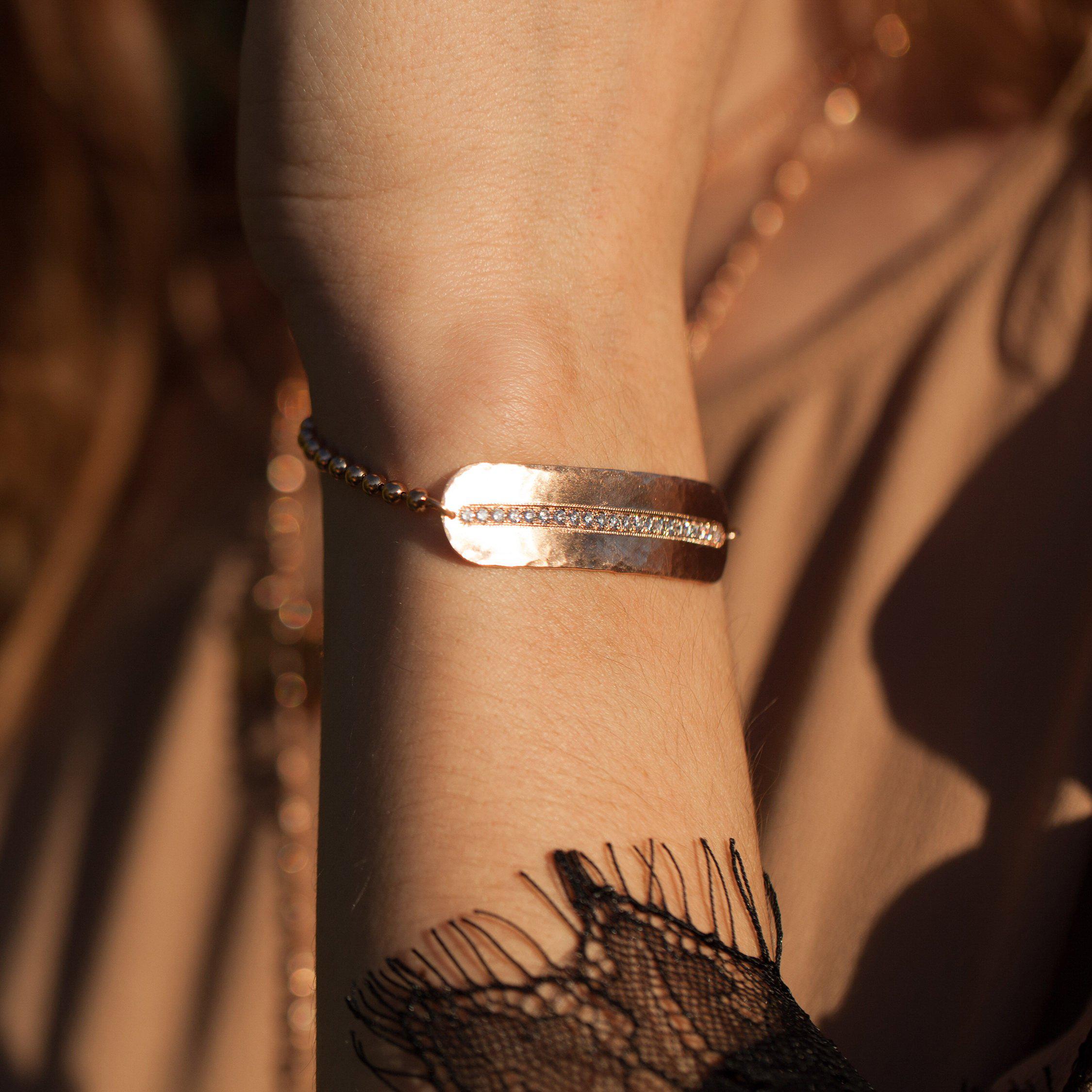 14k rose gold hammered bar bracelet featuring pave set white diamond line on ball chain on model in lifestyle shot