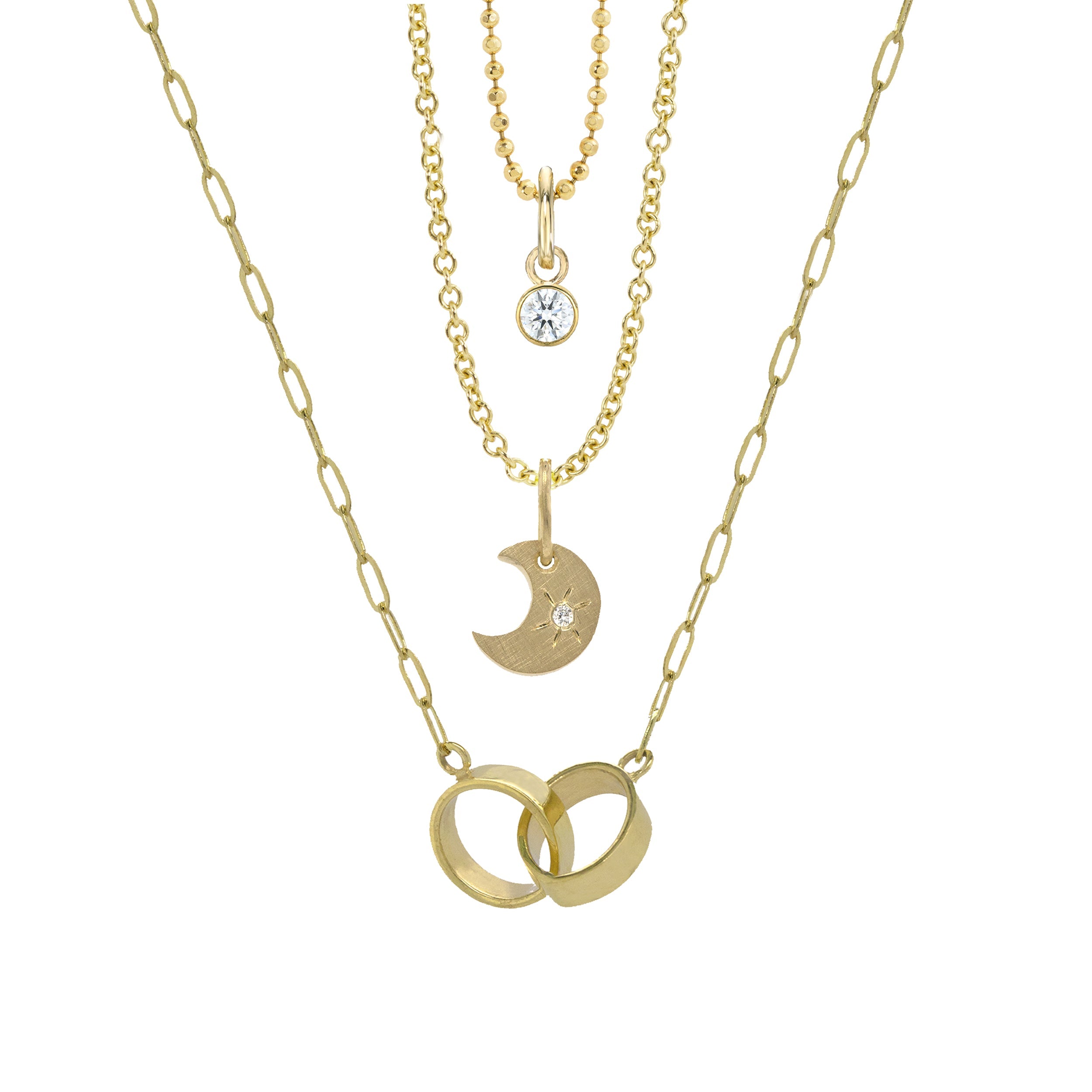 14k yellow gold crescent moon charm with a white diamond sunburst on a rolo chain on a white background stacked with bezi charm with white diamond on diamond cut ball chain and ally paperclip lilnk chain 