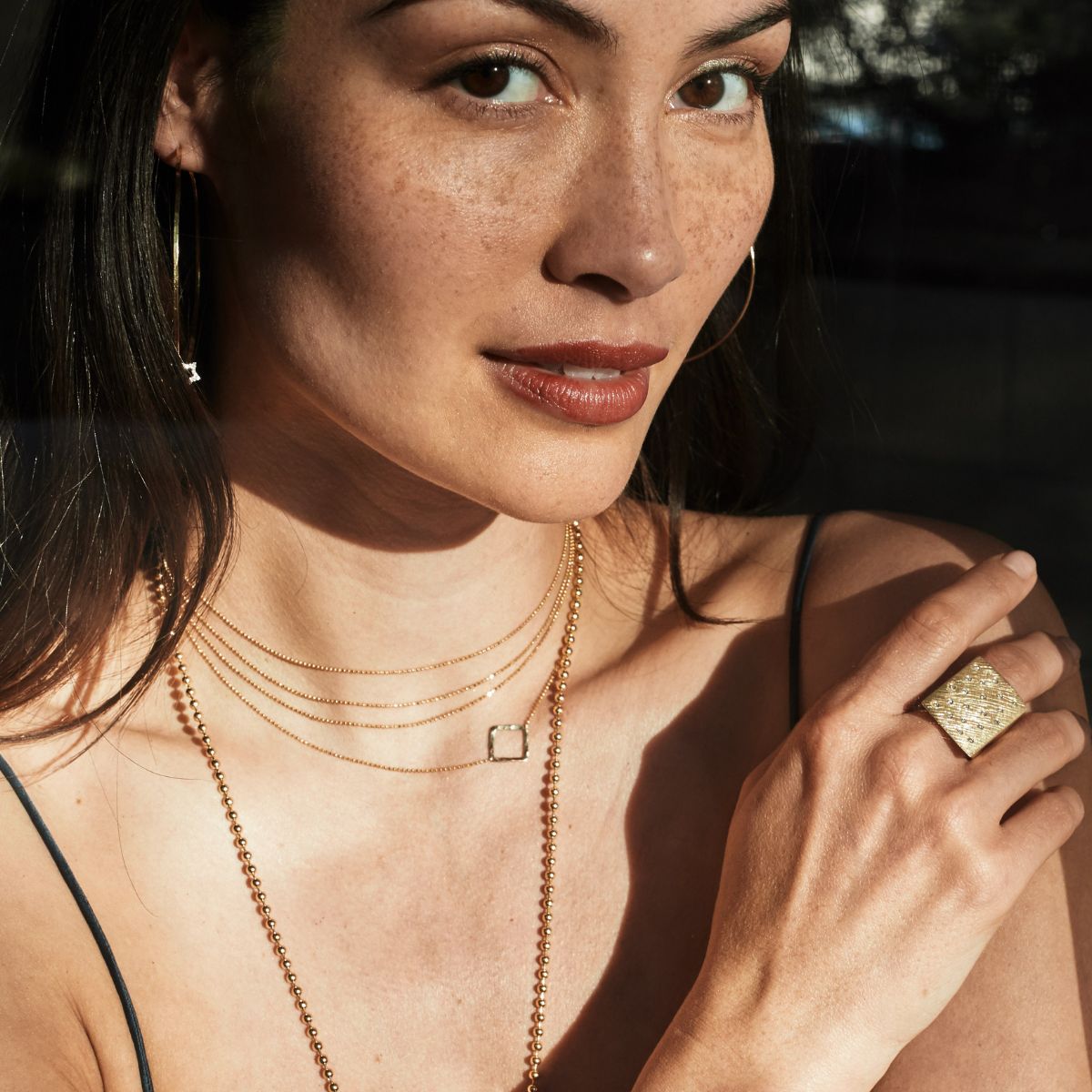 Model wearing layers of 14k chains and necklaces by Julez Bryant