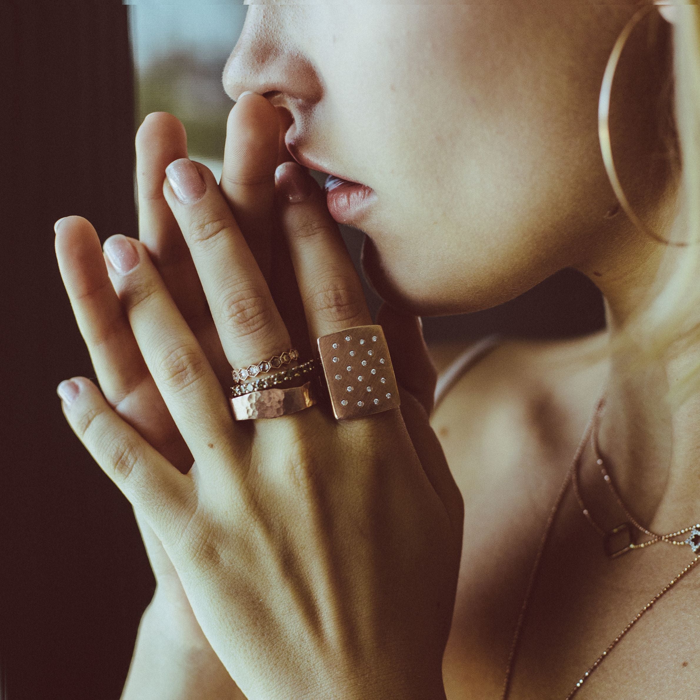 Model wearing layers of 14k cocktail rings and necklaces by Julez Bryant