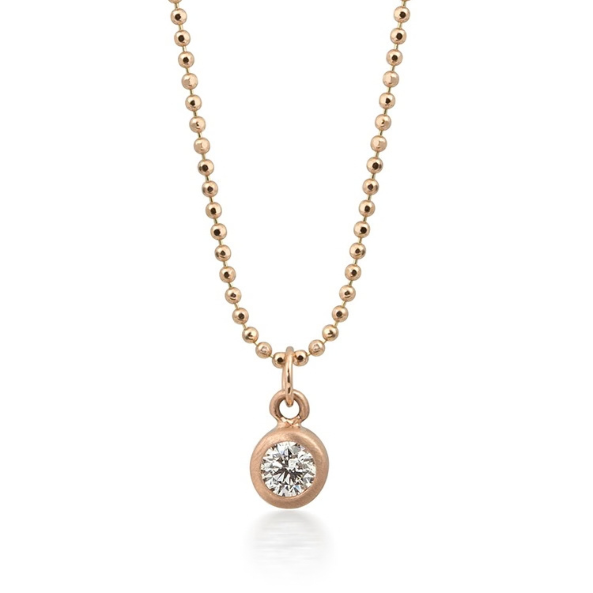 14k rose gold bezel set diamond pendant on a diamond cut ball chain on a white background