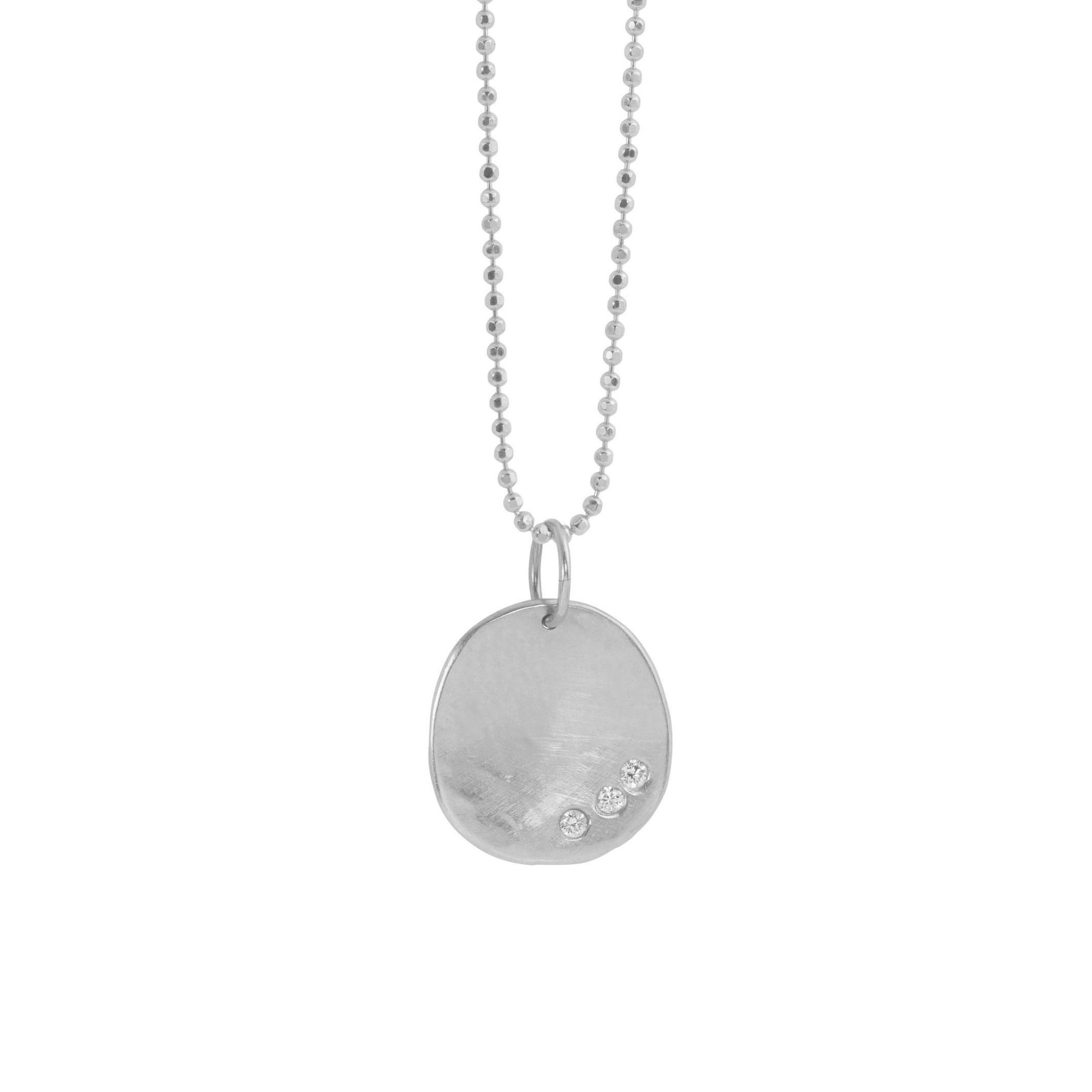 14k white gold round hammered pendant featuring three small white diamonds on a white background