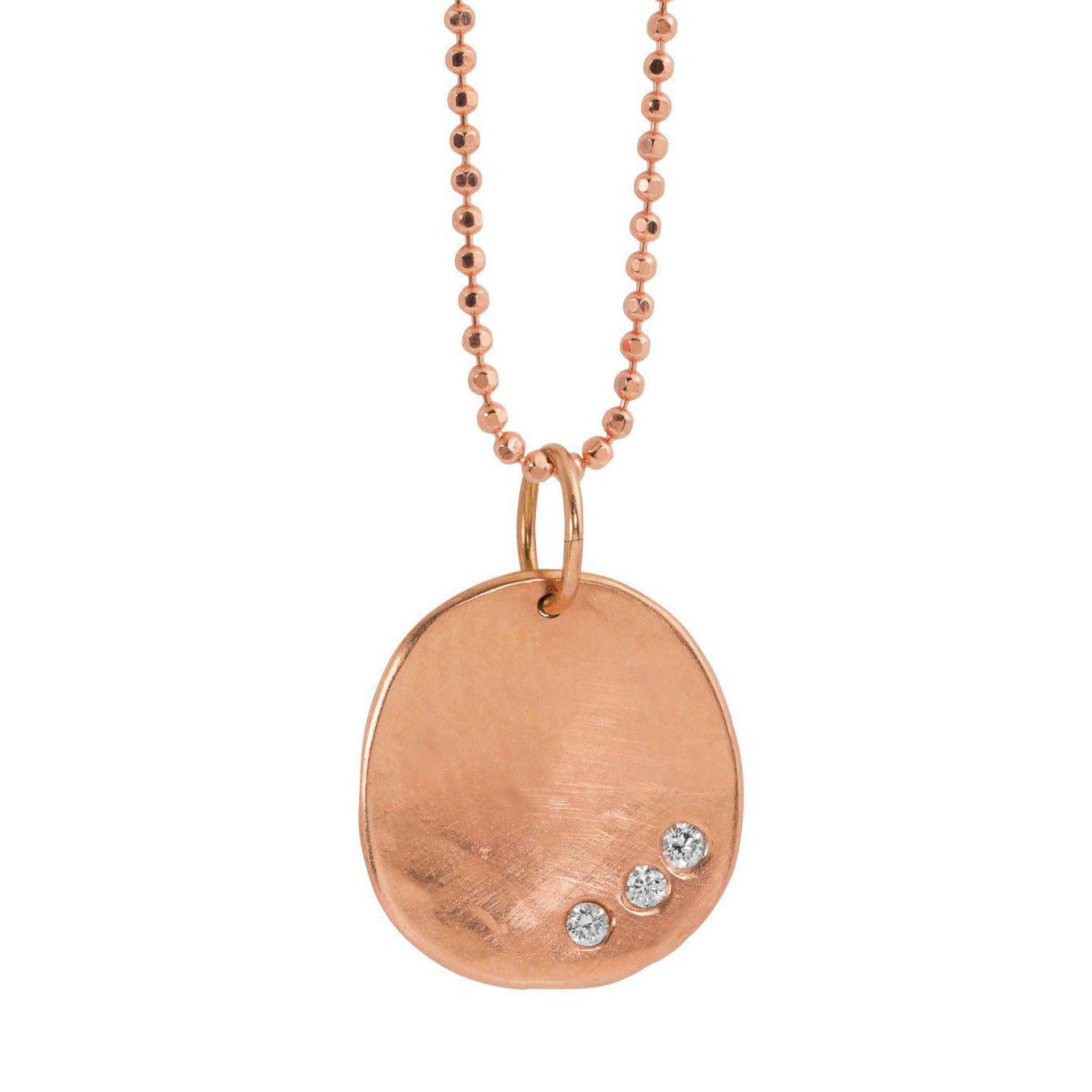 14k rose gold round hammered pendant featuring three small white diamonds on a white background