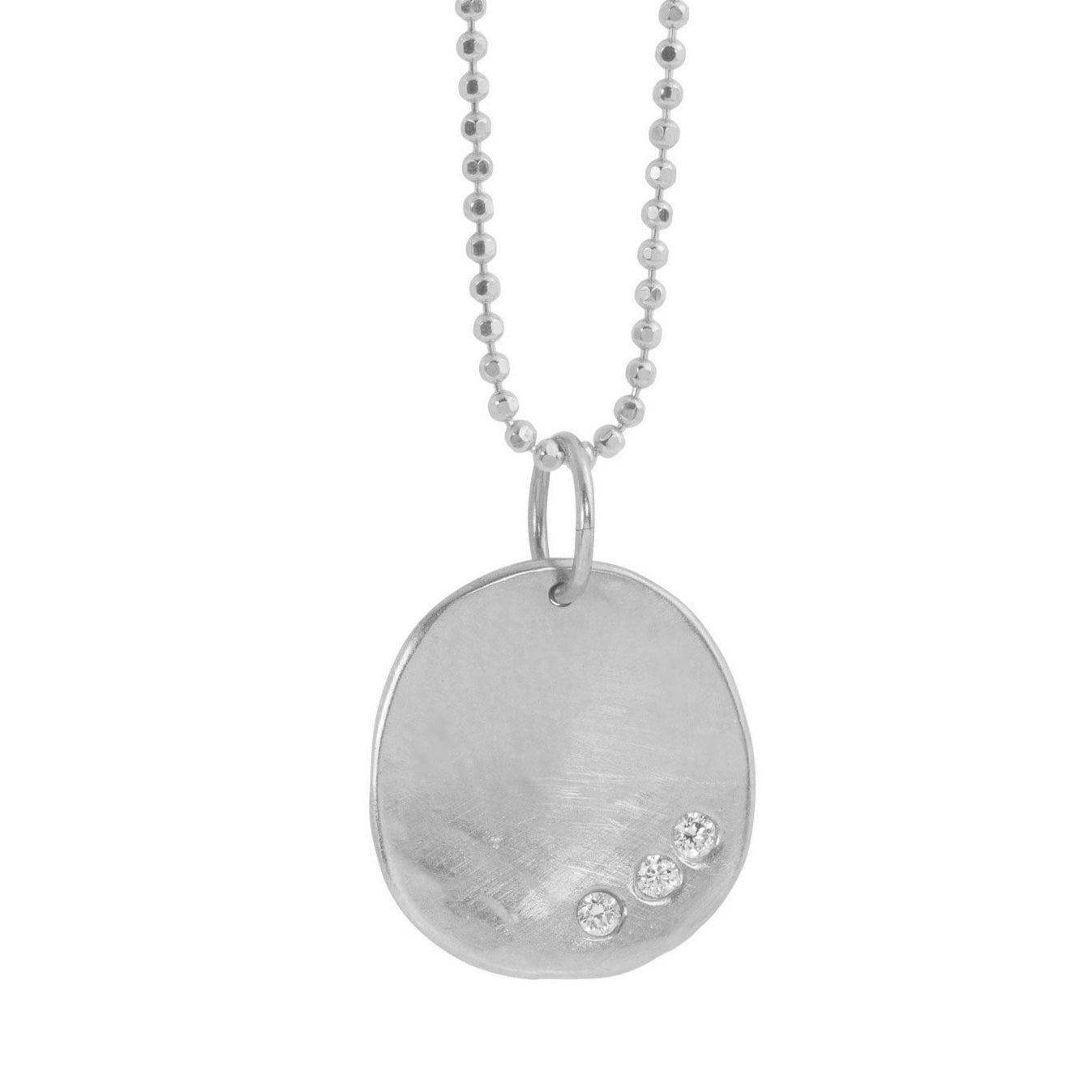 14k white gold round hammered pendant featuring three small white diamonds on a white background