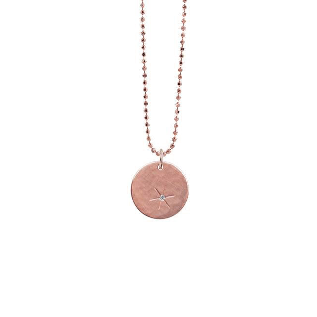 14k rose gold round pendant with hand etched starburst with white diamond on diamond cut ball chain on a white background