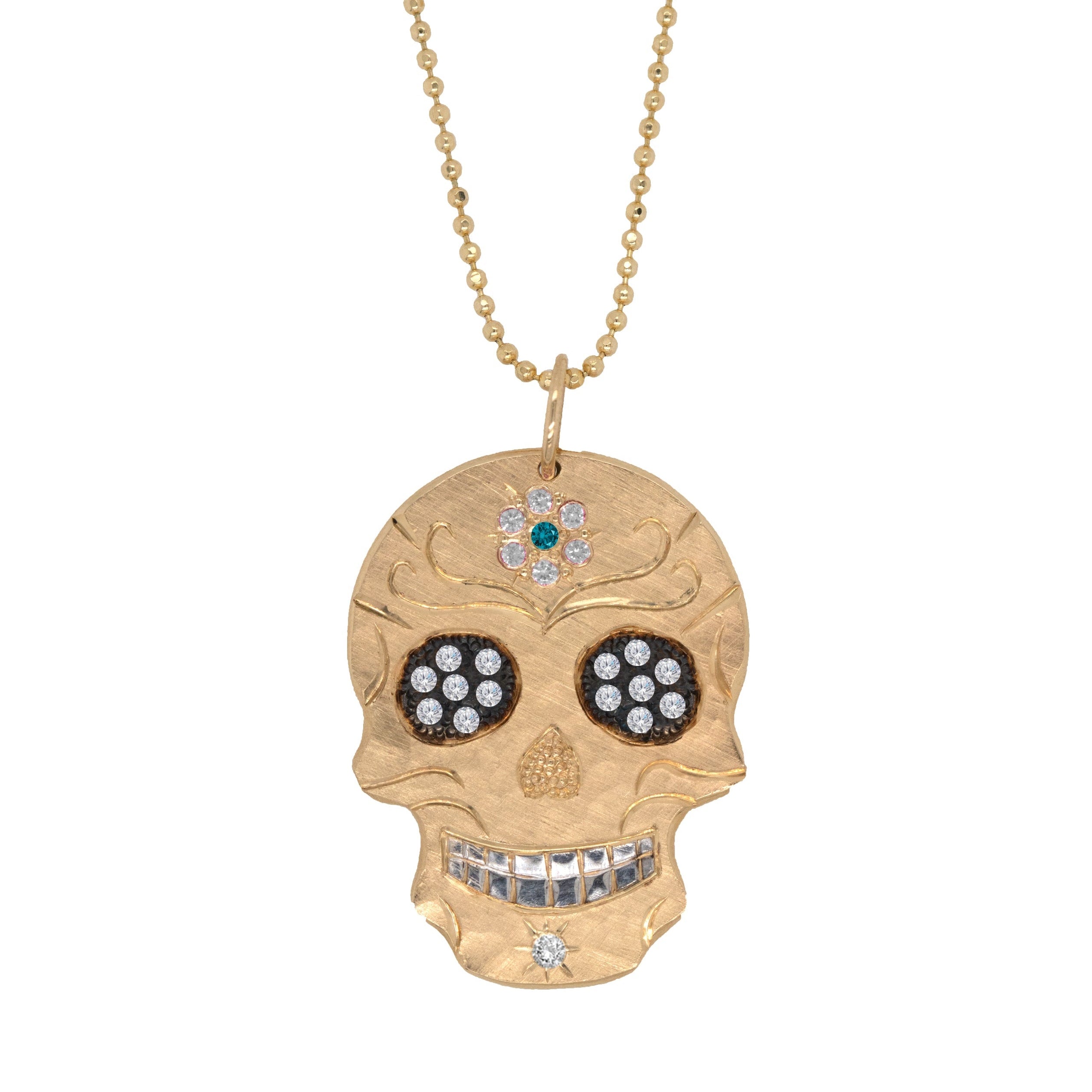 Gold skull pendant necklace with gemstones on a white background