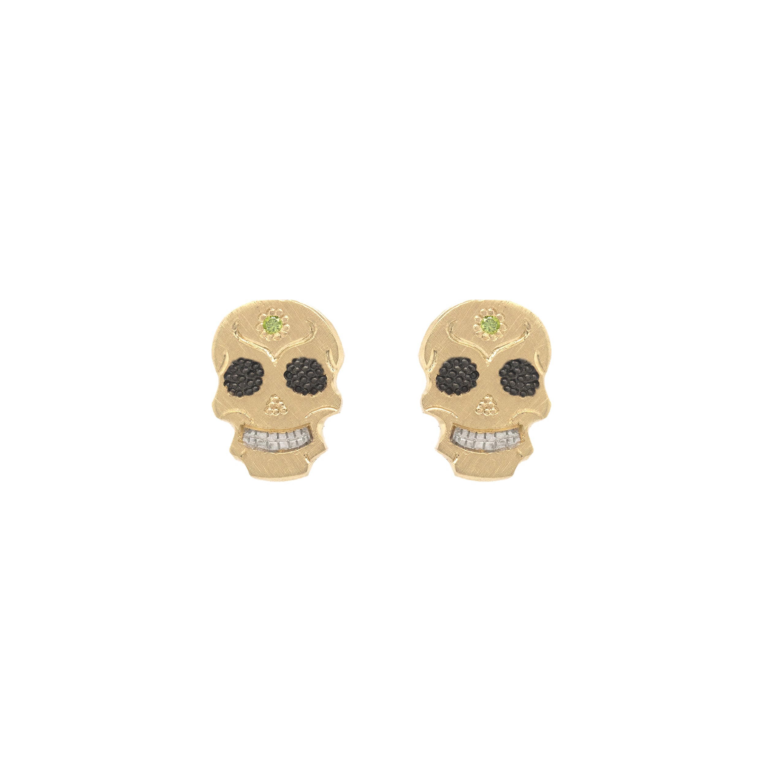 A pair of 14k gold earrings designed as skull charms with green diamond accents.
