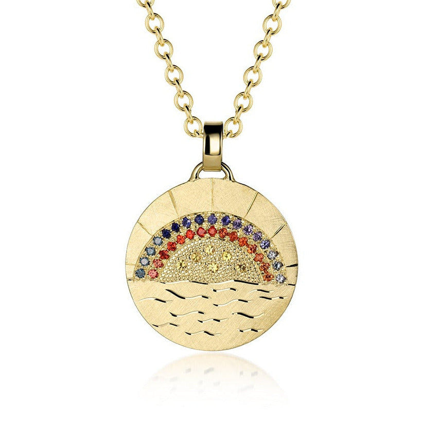 14k gold disk shaped pendant with hand engraved sun rays and ocean waves pave set sapphires and diamonds in vibrant rainbow design shown on a white background