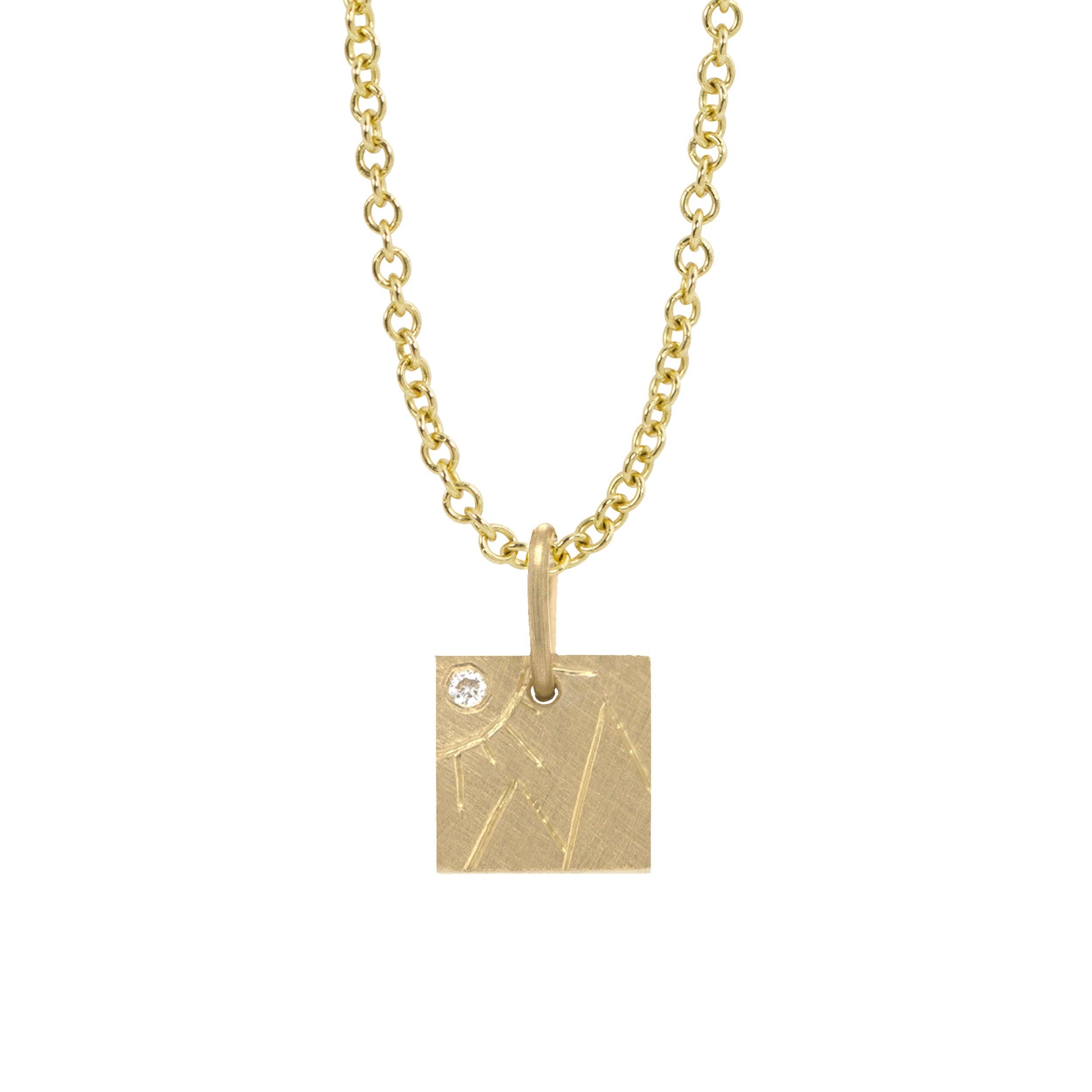 14k yellow gold square pendant with hand etched mountains and sun with white diamond on a white background