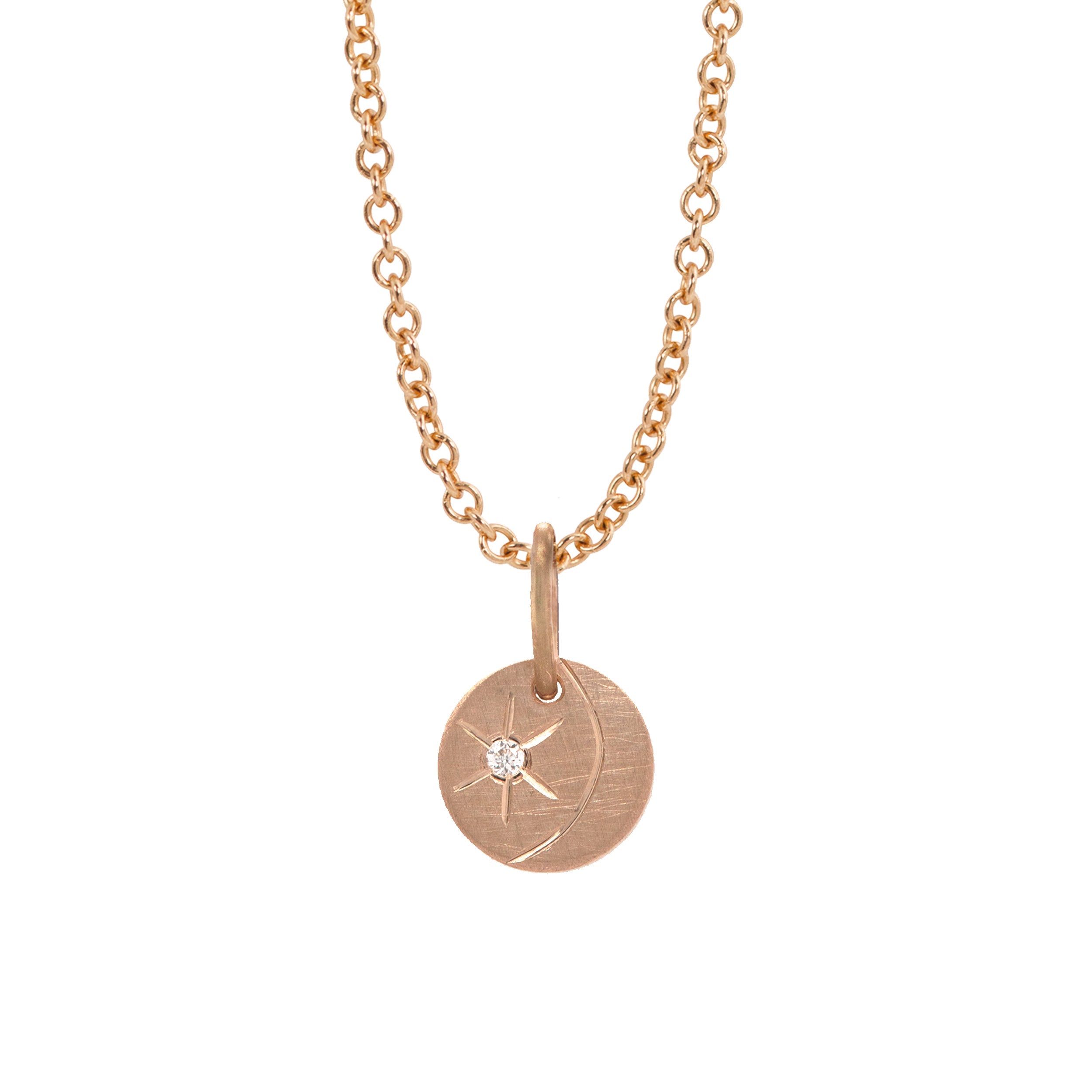 14k rose gold round pendant featuring a diamond starburst with an etched crescent moon on a white background