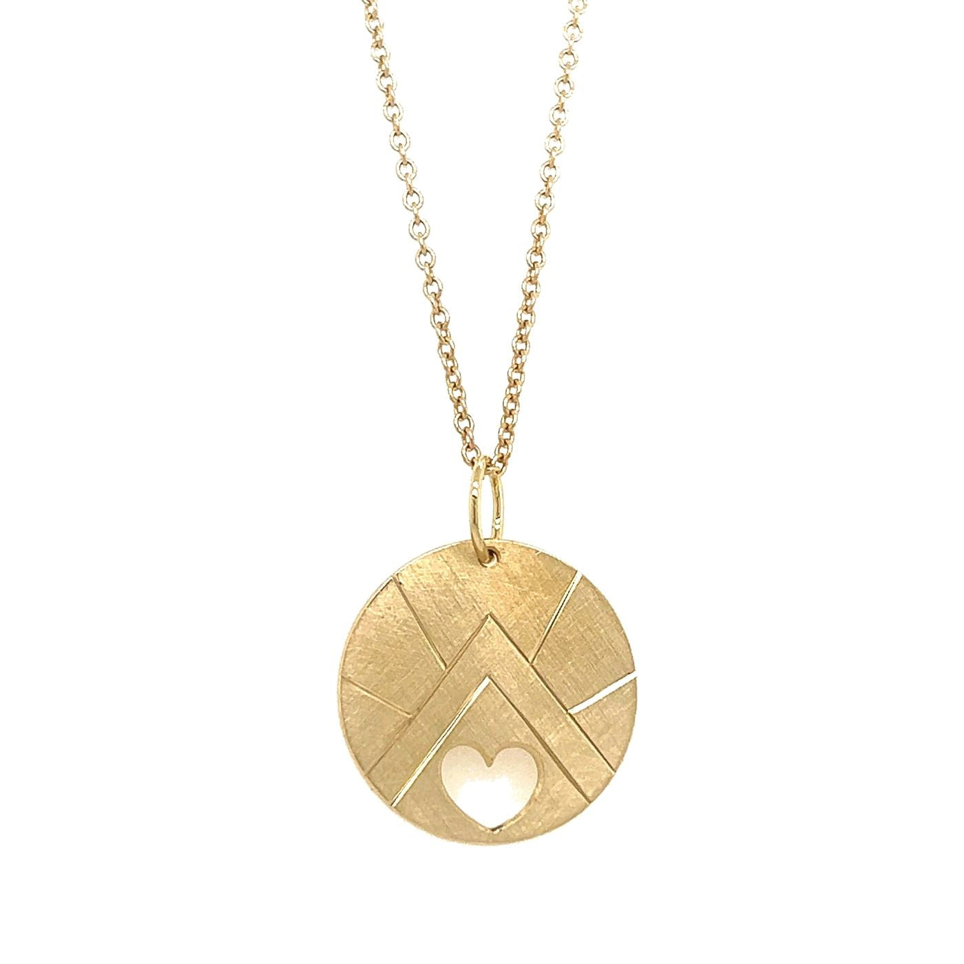 14k yellow gold round pendant with geometric mountain etching and heart cut out on a white background