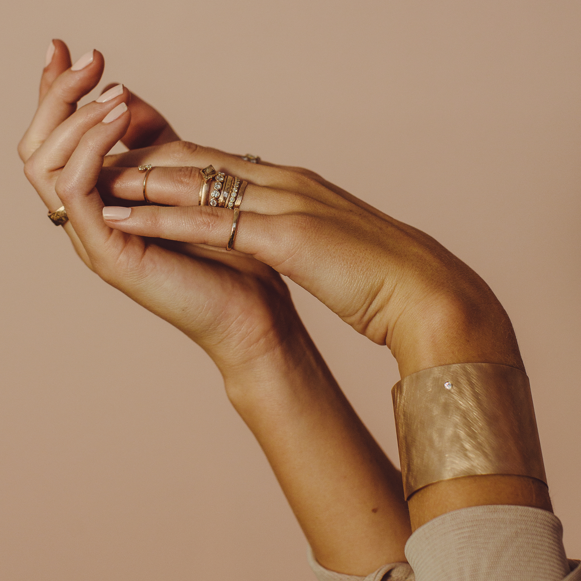 14k gold wide open cuff bracelet with white diamond accent on model in lifestyle shot