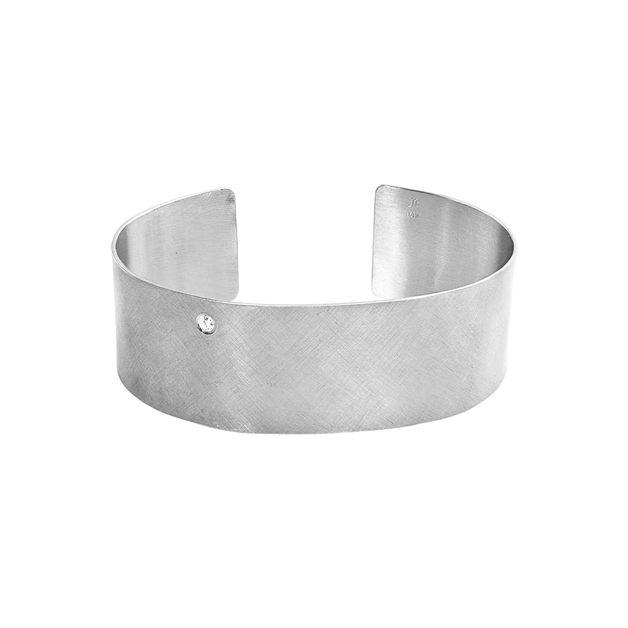 14k white gold satin finished wide cuff bracelet with single offset white diamond on white background