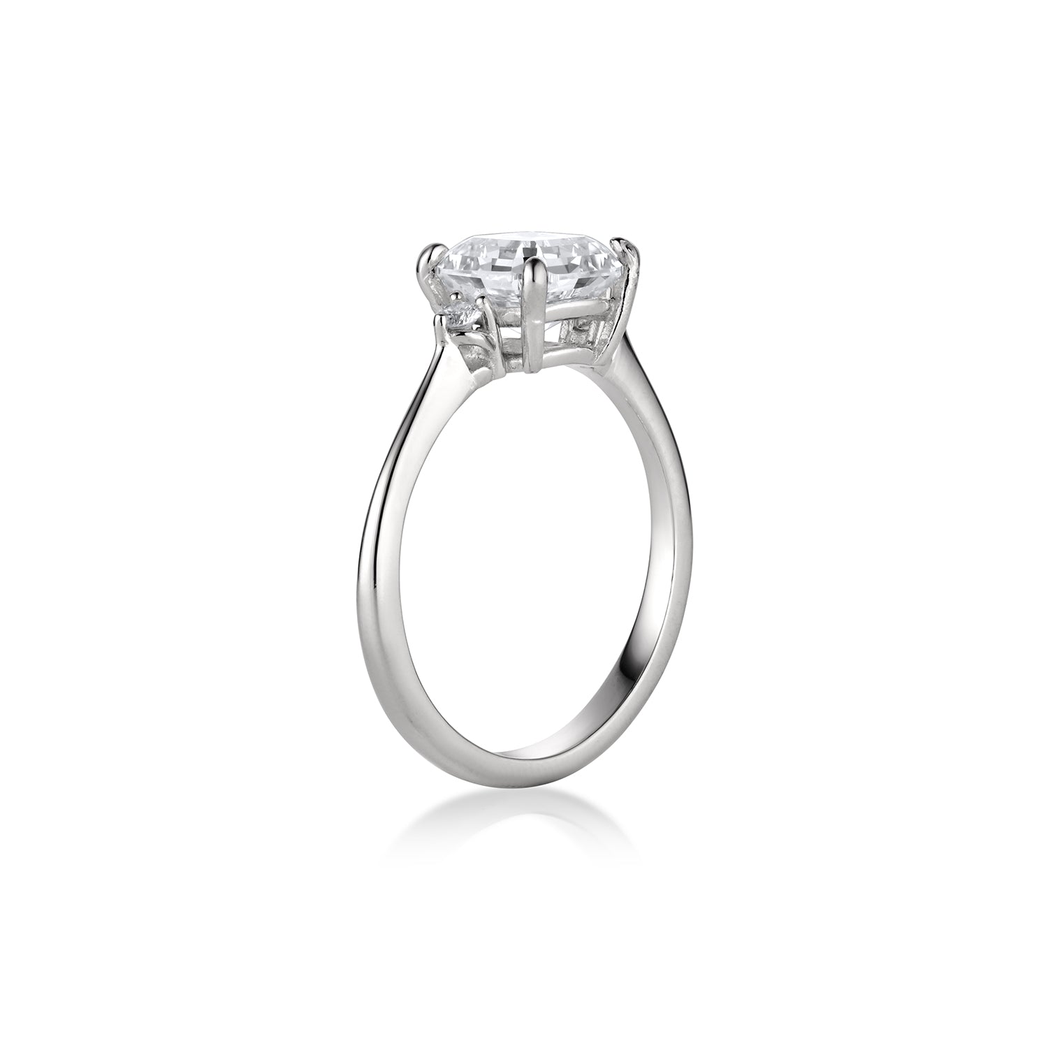 Three stone emerald and round cut white gold engagement ring thin band high polish side view on white background