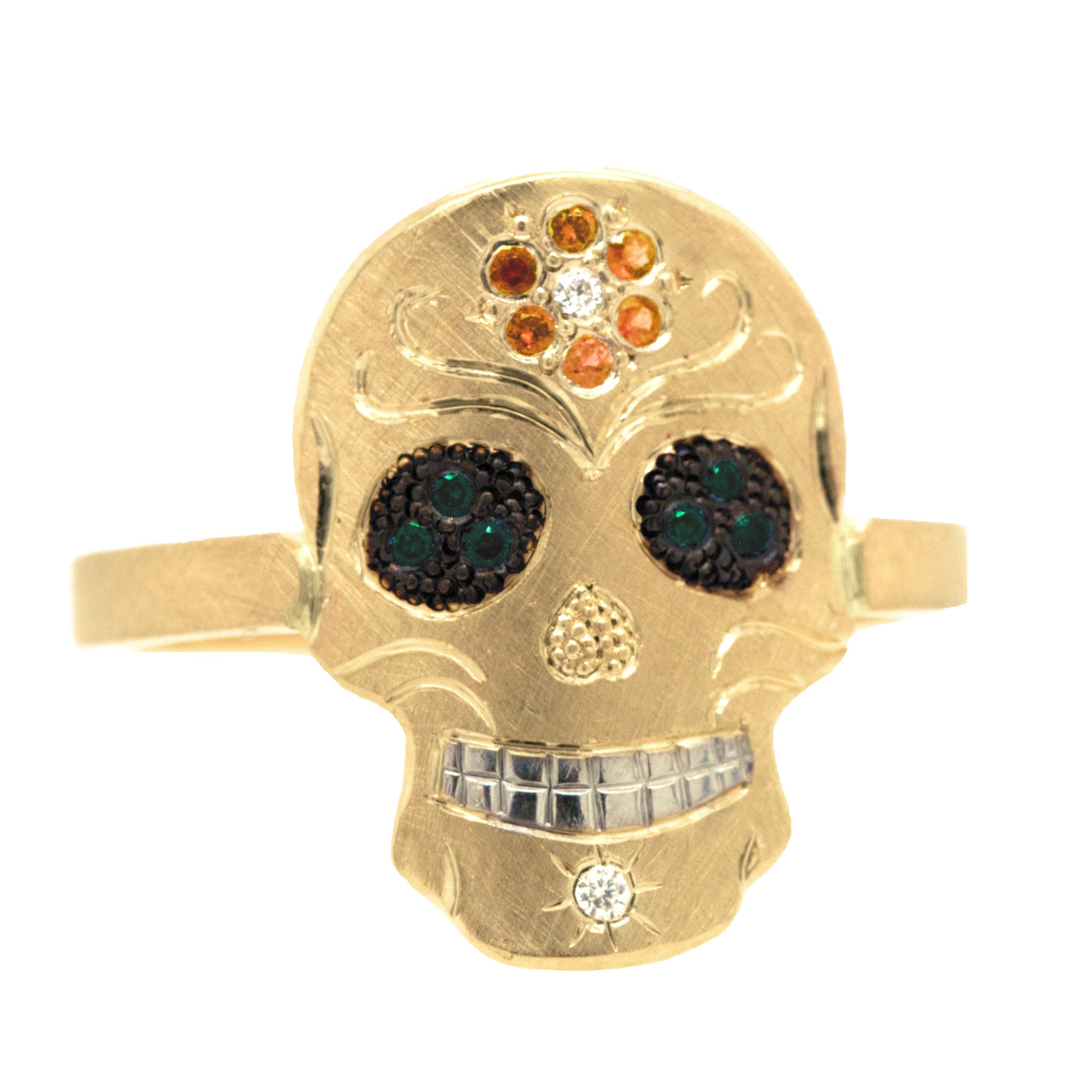 Gold skull-shaped ring with gemstones on a white background. Pave set orange sapphire flower on forhead, pave set eyes and diamond on chin. Fine engraving and milgrain detail.
