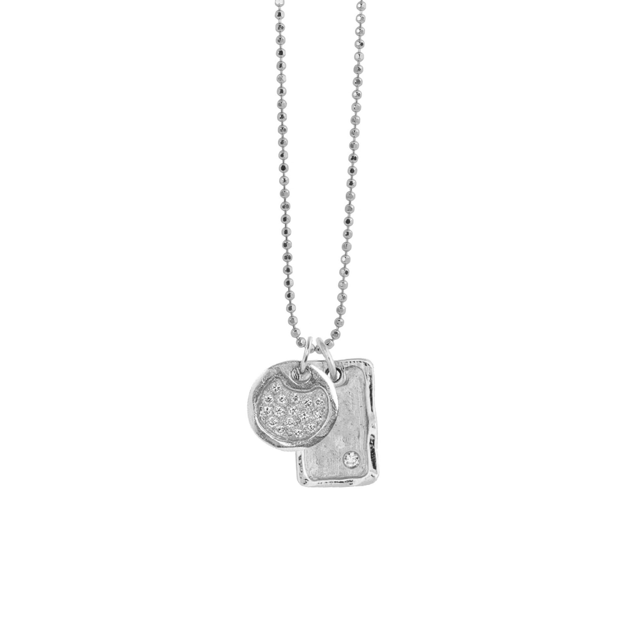 14k white gold round dogtag pendant featuring milgrain texture and scattered white diamonds paired with a rectangle dog tag with single offset white diamond on diamond cut ball chain on white background