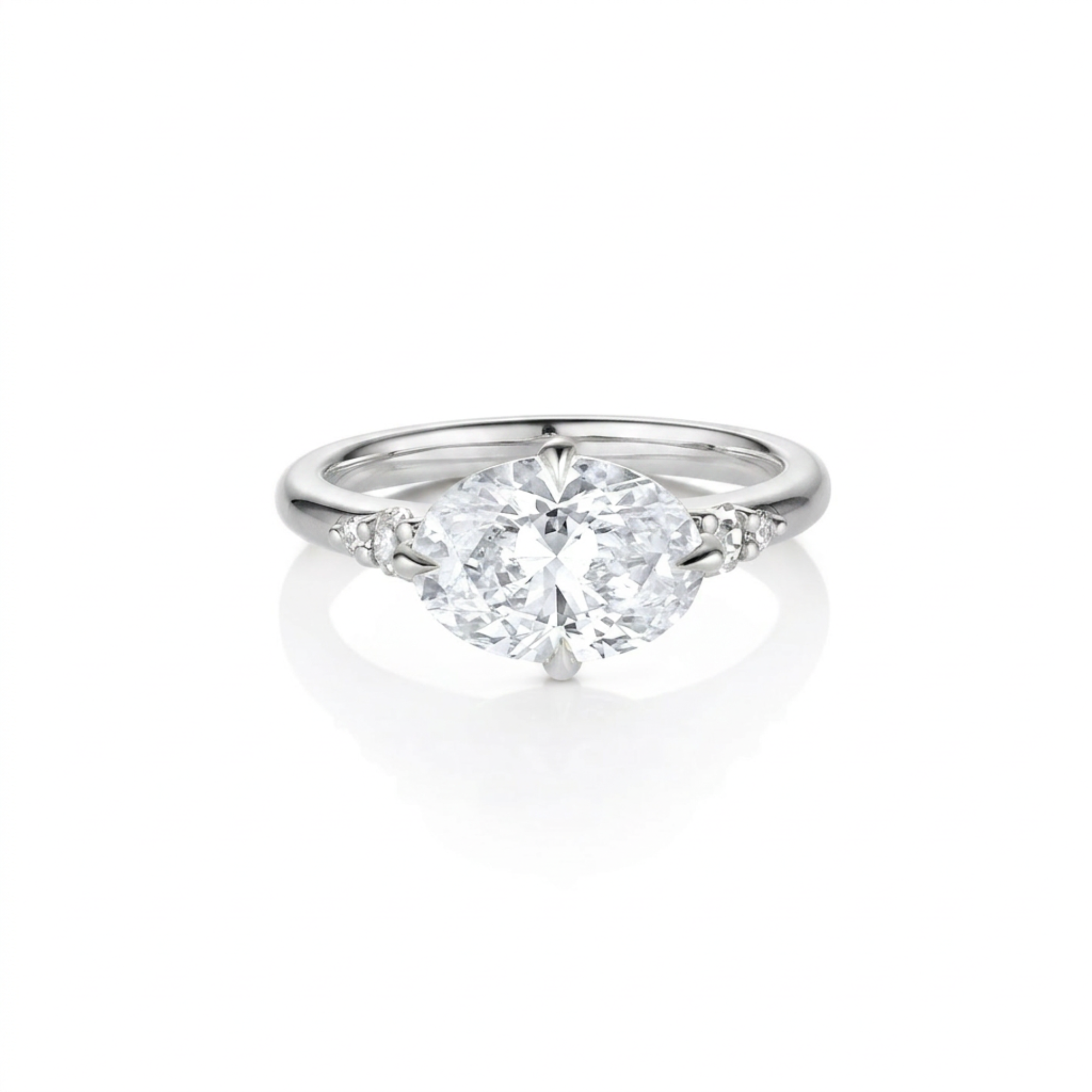 Top down view of five stone large oval sideways east-west setting white diamond with round accents either side 14k rose gold engagement ring on white background