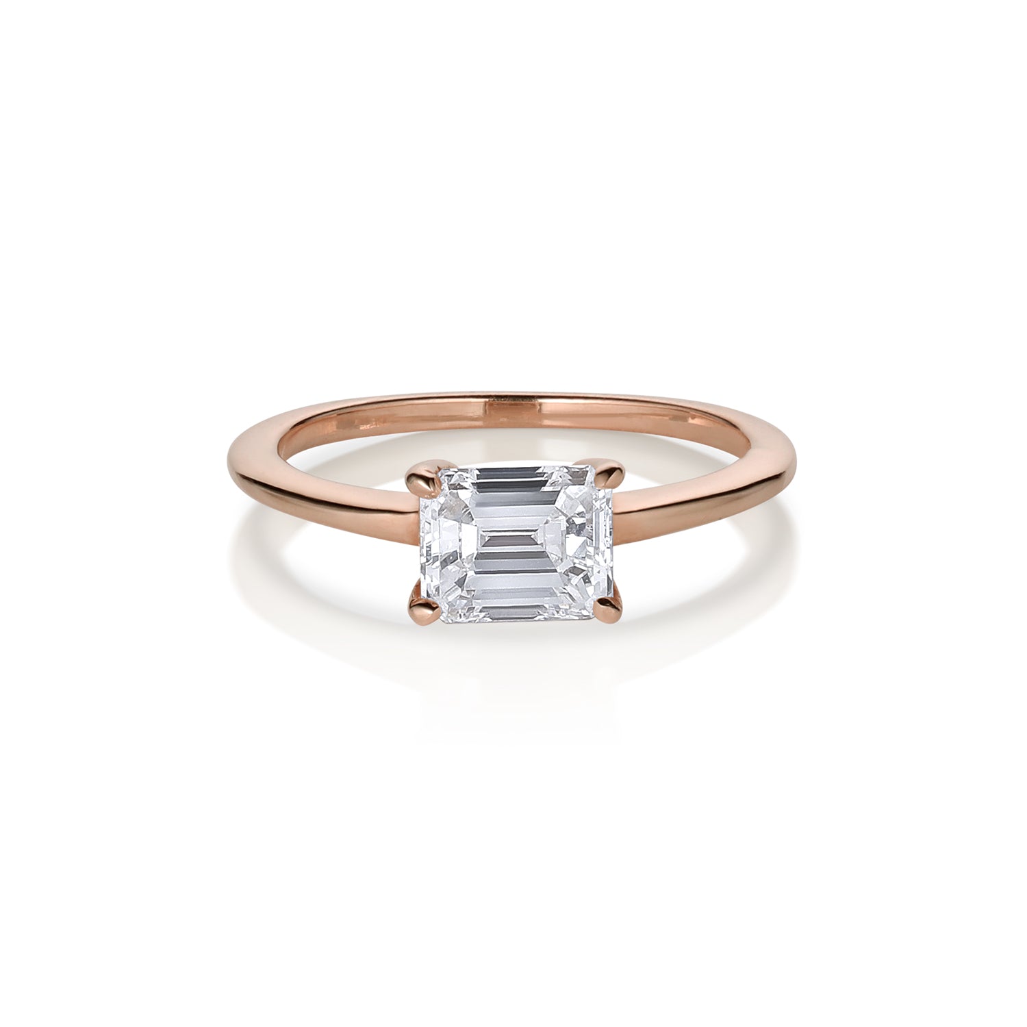 14k rose gold emerald cut white diamond solitaire engaement ring shown on white background.