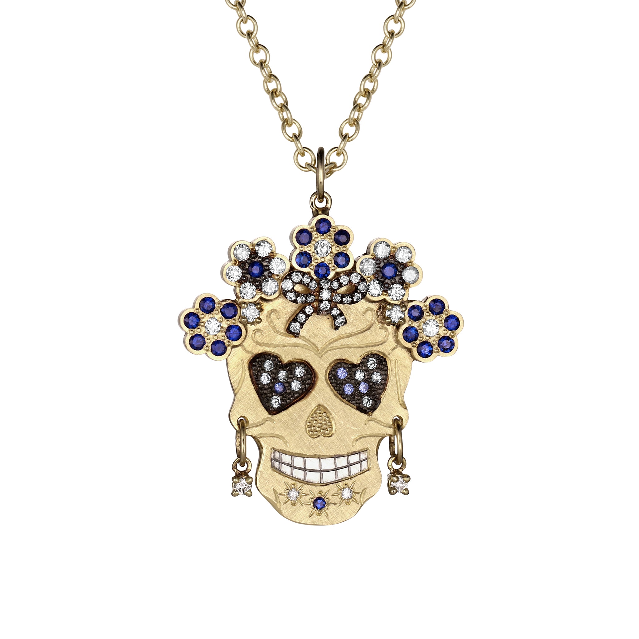 Elaborate gemstone encrusted Skull-shaped pendant necklace with white diamond and blue sapphires features a halo of flowers, bow on forehead,heart shaped eyes, wearing diamond hoop earrings Shown closeup with round link chain on white background