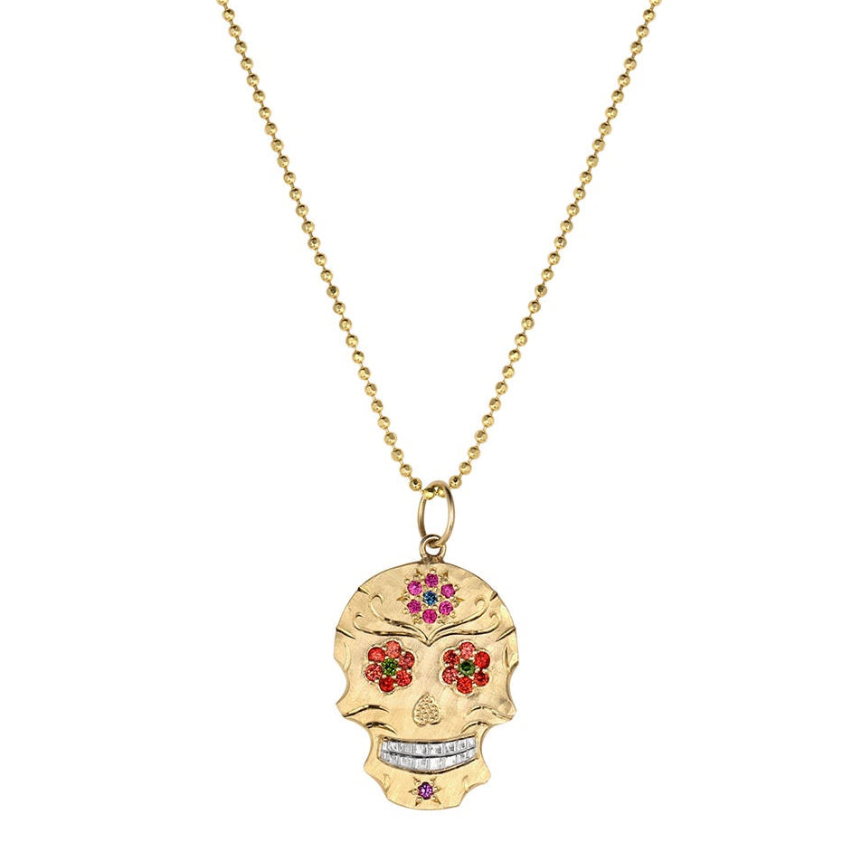 Gold skull shaped pendant necklace with colorful gemstone floral eyes on a white background.Featured on 14k gold ball chain.