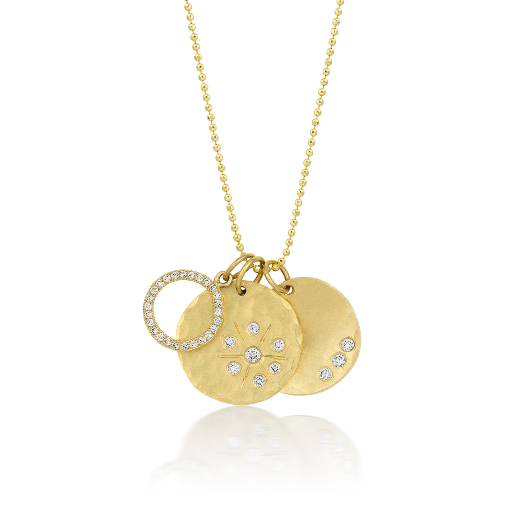 14k yellow gold round hammered pendant featuring three small white diamonds stacked with an open circle pendant with paved set white diamonds and a round pendant with a hammered finish and hand etched starburst with white diamonds on a white background