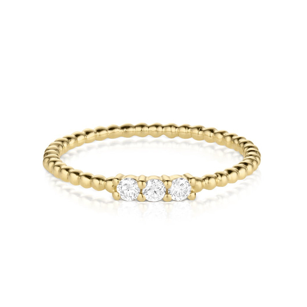 Beaded 14 k gold ring with three diamonds on a white background