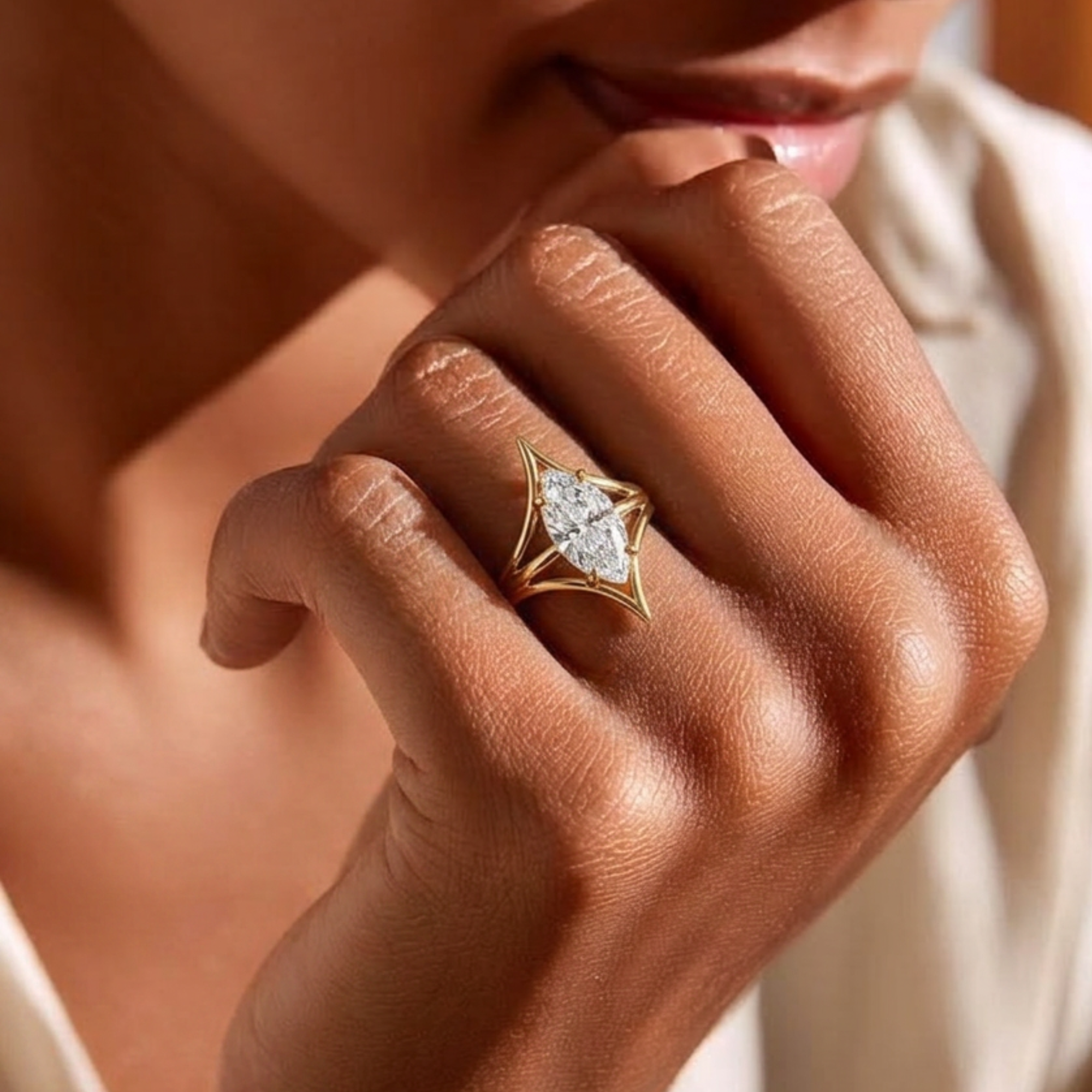 Marquise cut white diamond cage solitaire engagement ring with modern setting in 14k yellow gold, lifestyle shot worn on a model's hand