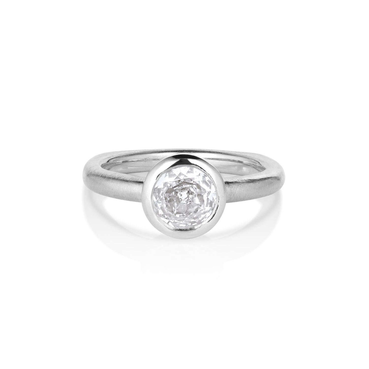 Solitaire white gold ring with single stone bezel set on unique shaped shank, on a white background