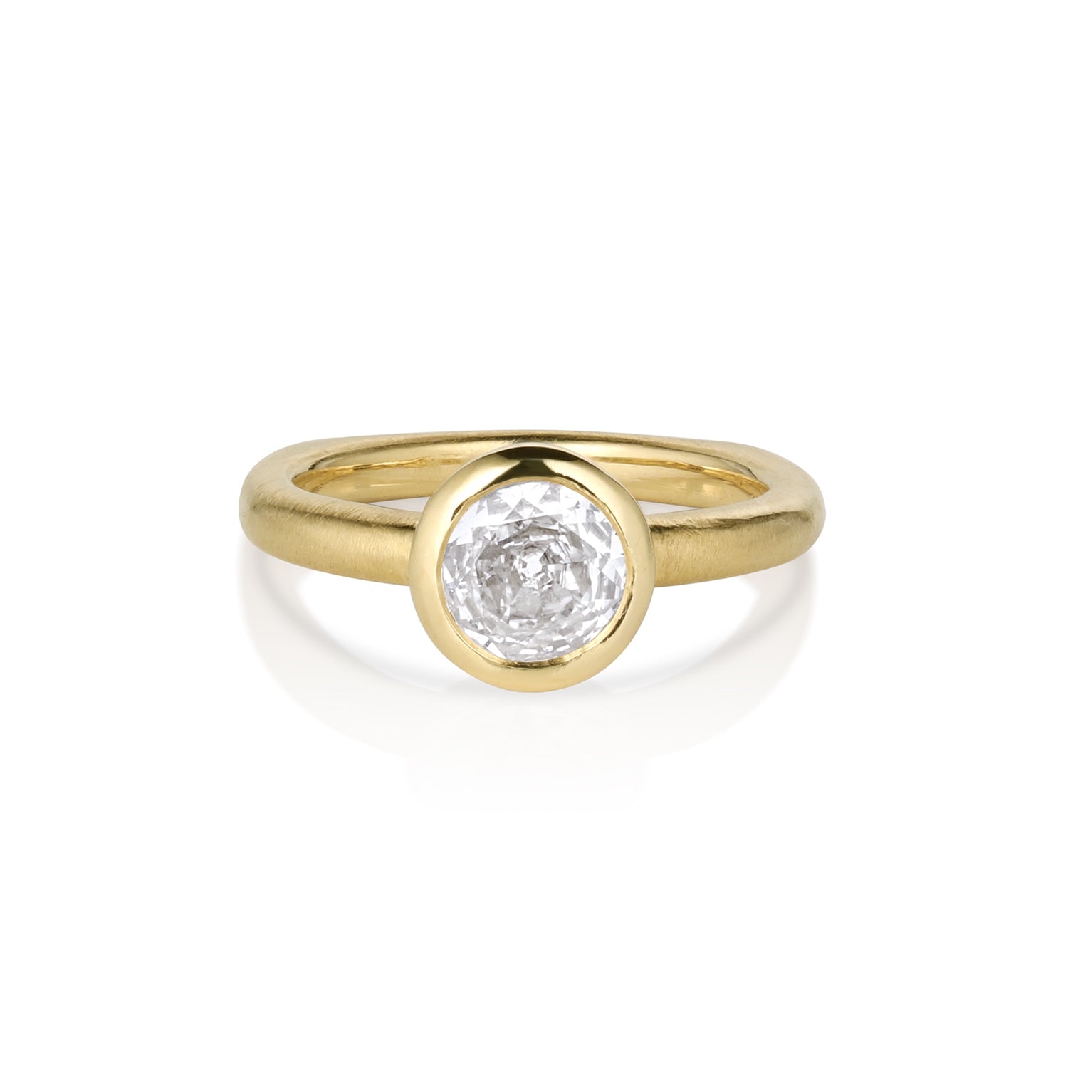 Solitaire yellow gold ring with single stone bezel set on unique shaped shank, on a white background