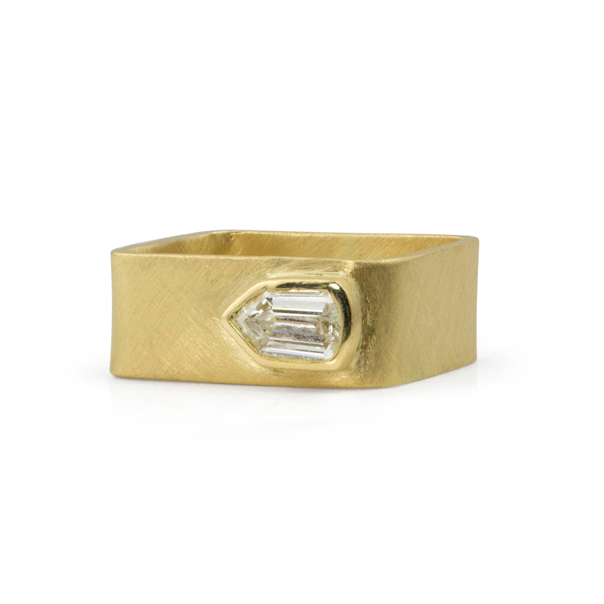 Thick wide band 14k yellow gold ring with offset sideways shield cut diamond bezel setting with brushed satin finish shown on white background