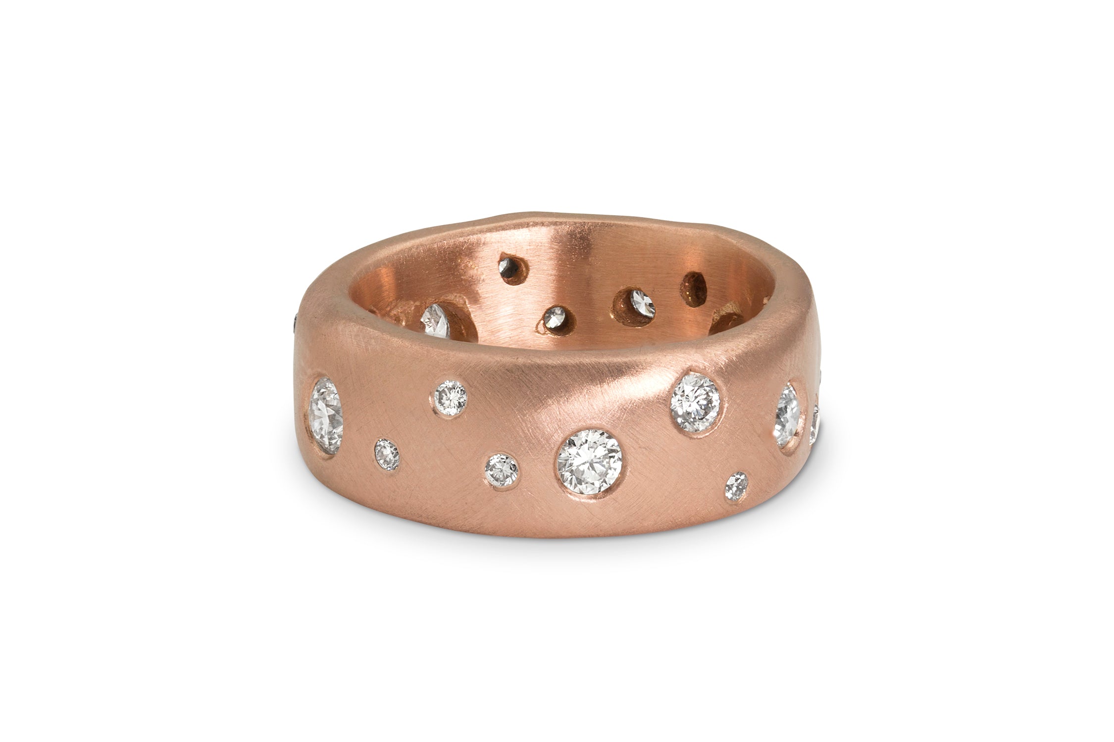 Rose gold thick band ring with embedded white diamonds on a white background