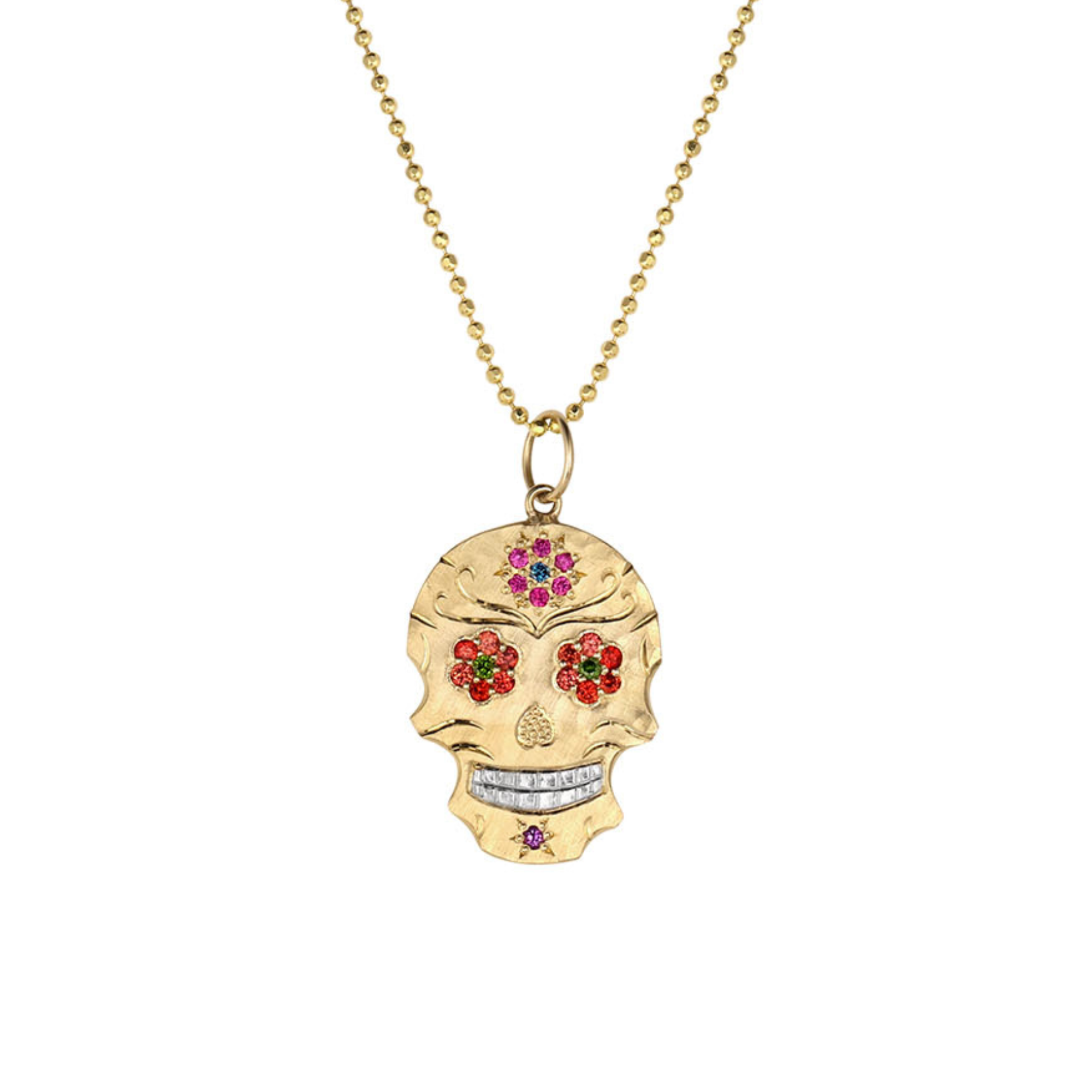 A dainty gold sugar skull pendant necklace on a gold ball chain, featuring red, green, and pink gemstone floral details and a shiny silver mouth, set against a plain white background.