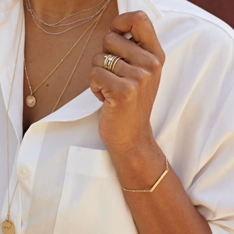 14k gold GNAB bar bracelet on model