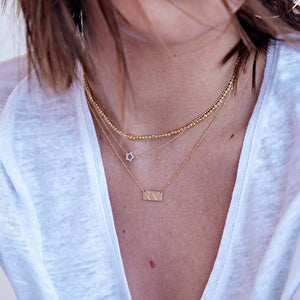 14k gold COCI necklace on model with STAR and MOCA