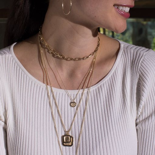 14k gold baby DENA round dog tag with scattered diamonds on model