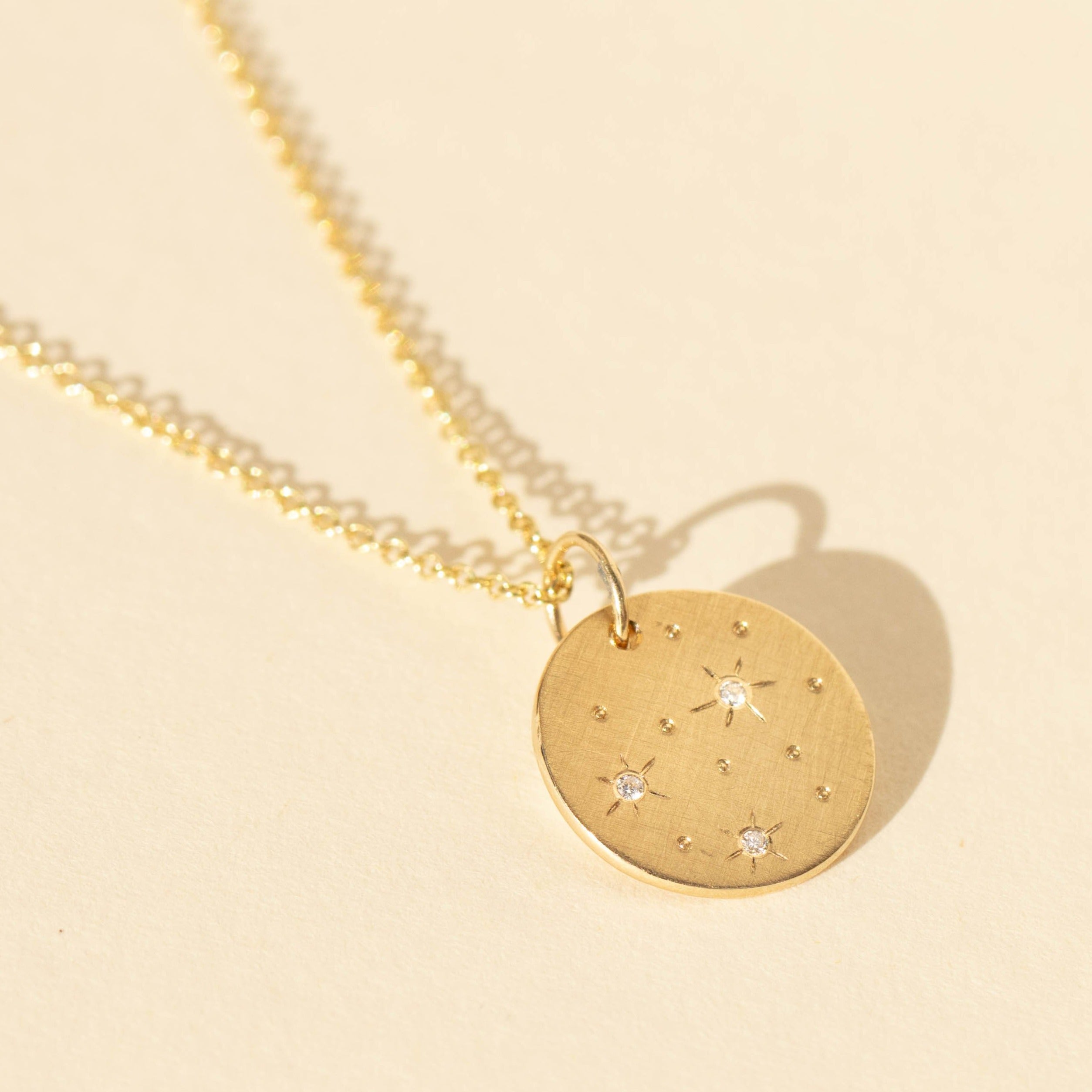 14k gold GATZ charm with diamond stars in studio