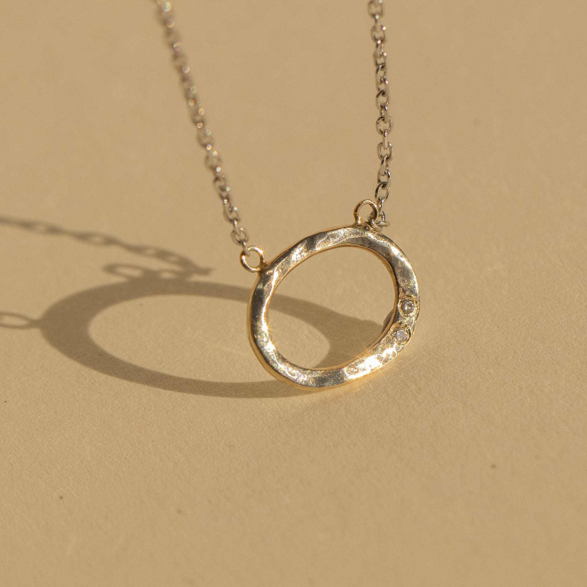 14k gold GOOZ circle necklace with diamonds in studio